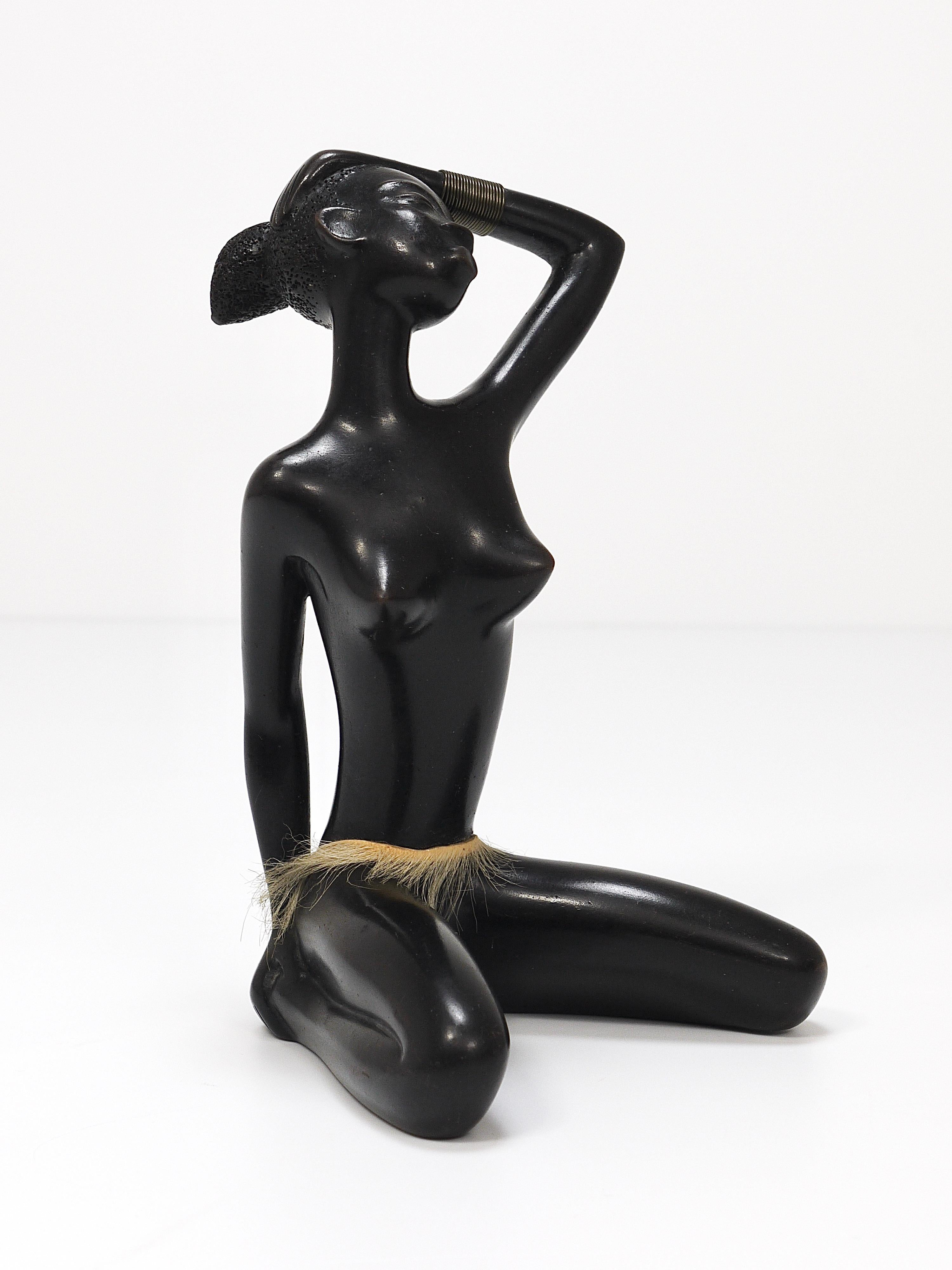 Une belle et décorative sculpture/figurine détaillée, vintage des années 1950, représentant une femme africaine nue assise avec un bracelet en laiton portant une jupe. Conçu et fabriqué à la main par Leopold Anzengruber à Vienne, en Autriche. Une
