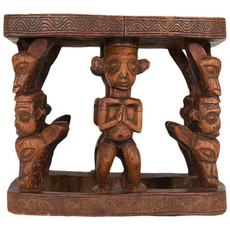 A hand-carved wooden stool featuring sculpted figures. Carved from a dense wood, a beautiful decorative object and functional piece of furniture. In excellent condition.