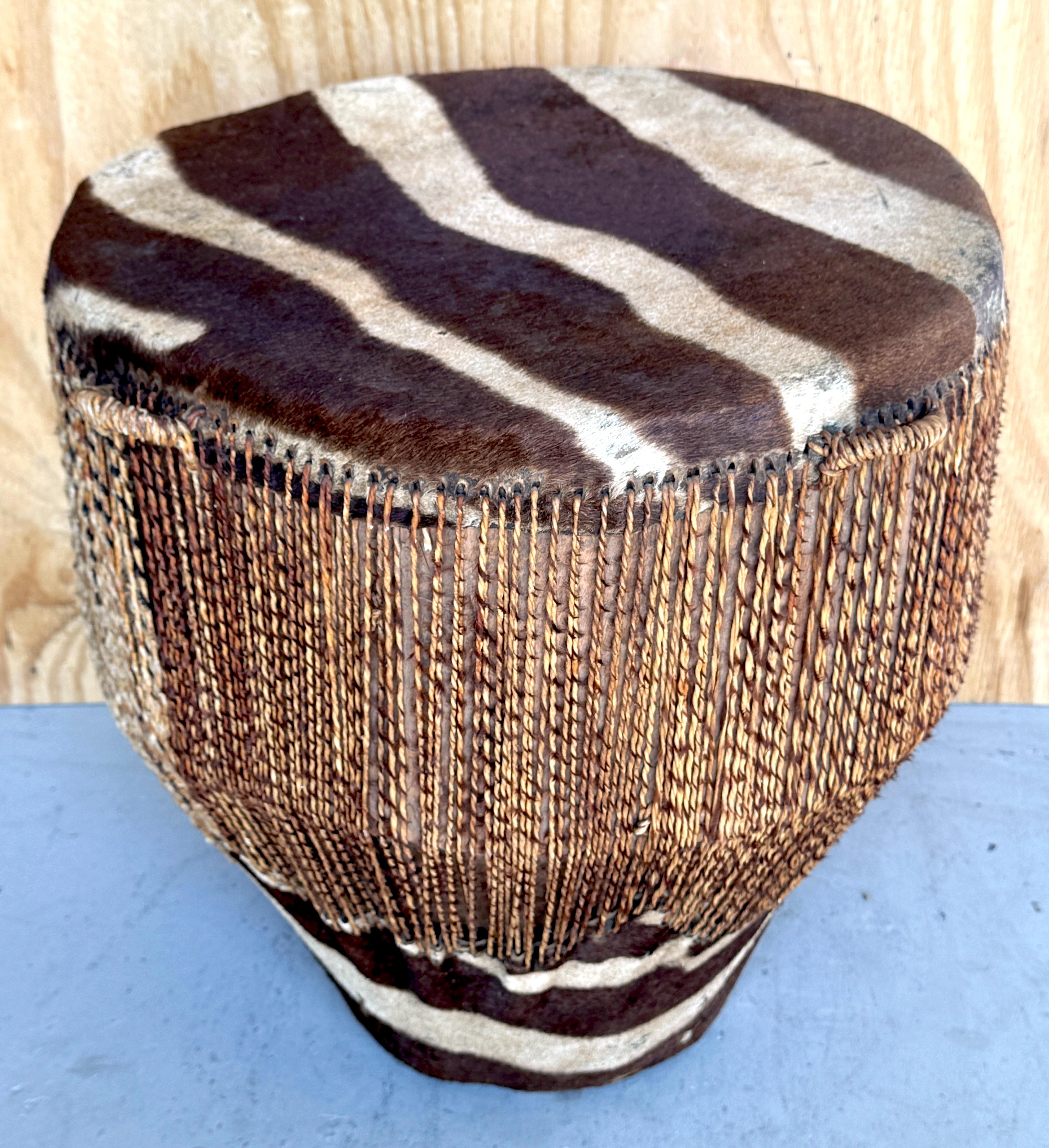 Tambor/Mesa auxiliar de cuero y piel de cebra africana

Este auténtico tambor/mesa auxiliar de piel y cuero de cebra africana es una impresionante obra de arte tribal que sirve también como mesa auxiliar o de bebidas. Con 21,5 pulgadas de alto y