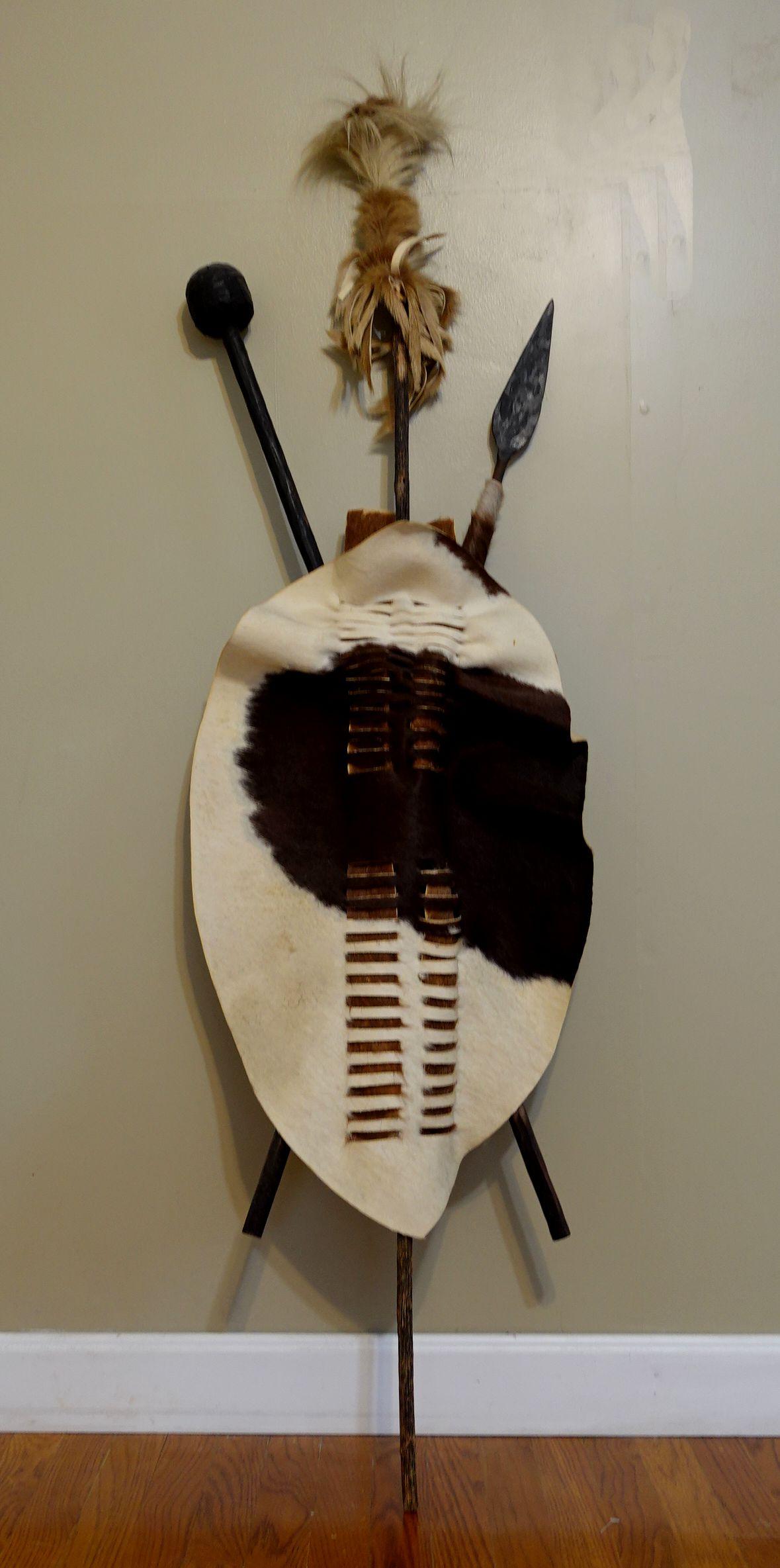 Seltenes Kunstwerk vom Stamm der Zulu in Afrika, die einheimische Waffe, um den Feind und das Tier anzugreifen und sich zu schützen. Eine typische Form ist ein Schild aus Kuhfell, auf dem Speer und Schlegel gekreuzt sind und das mit einem Fell und