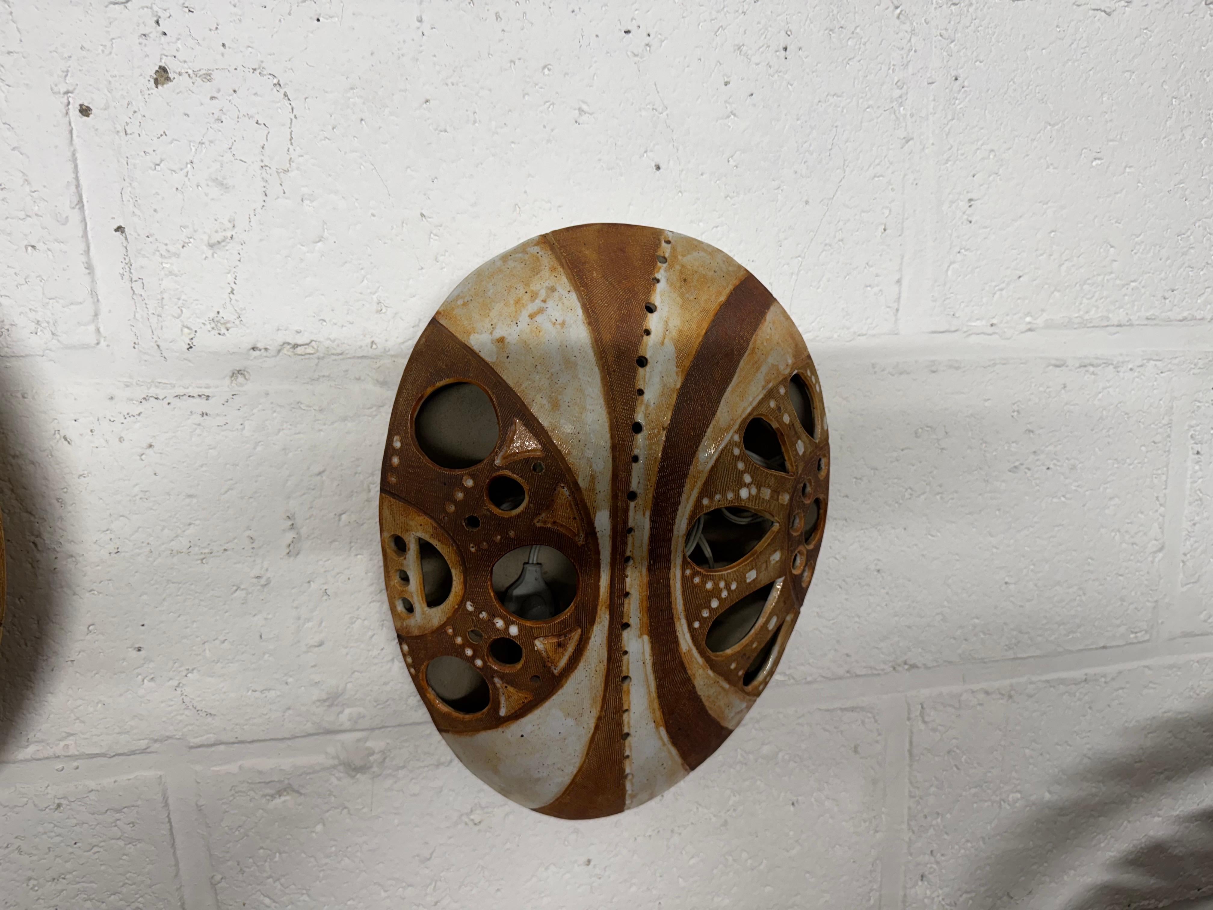 An unusual pair of ceramic africanist wall decorations also be sconces 