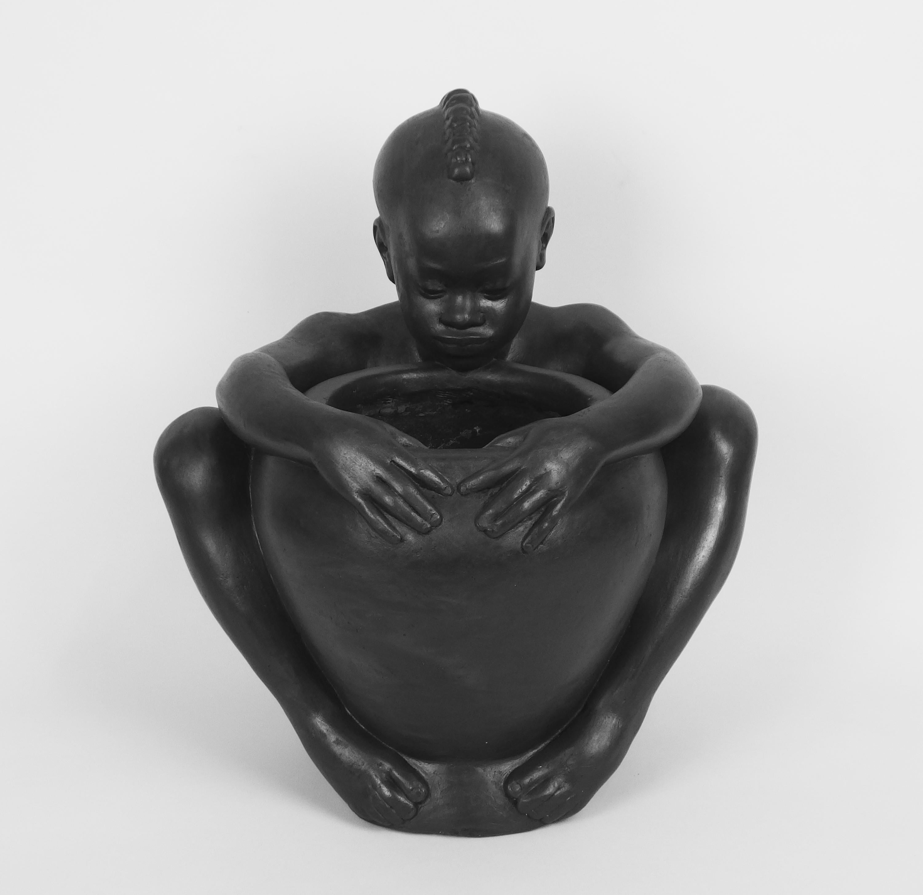 A black patinated plaster figure of a sitting young black boy holding a vase in his hands.
created by Riccardo Scarpa, circa 1960.
Riccardo Scarpa(1905-99)born in Venise ,studied at the royal academy of Venise art school, he lived in Paris from