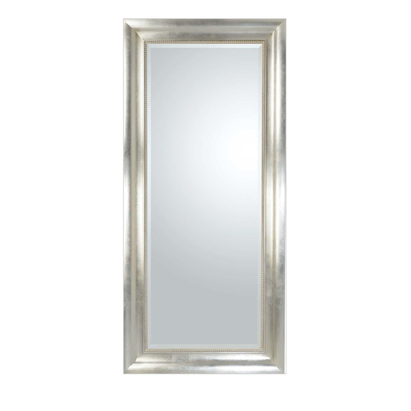 Distinguished by the antiqued champagne-colored silver-leaf coating adorning the wood frame, this wall mirror exudes a timeless allure. The 13cm-wide frame is minutely finished by hand and encloses a rectangular beveled mirror in prized Italian