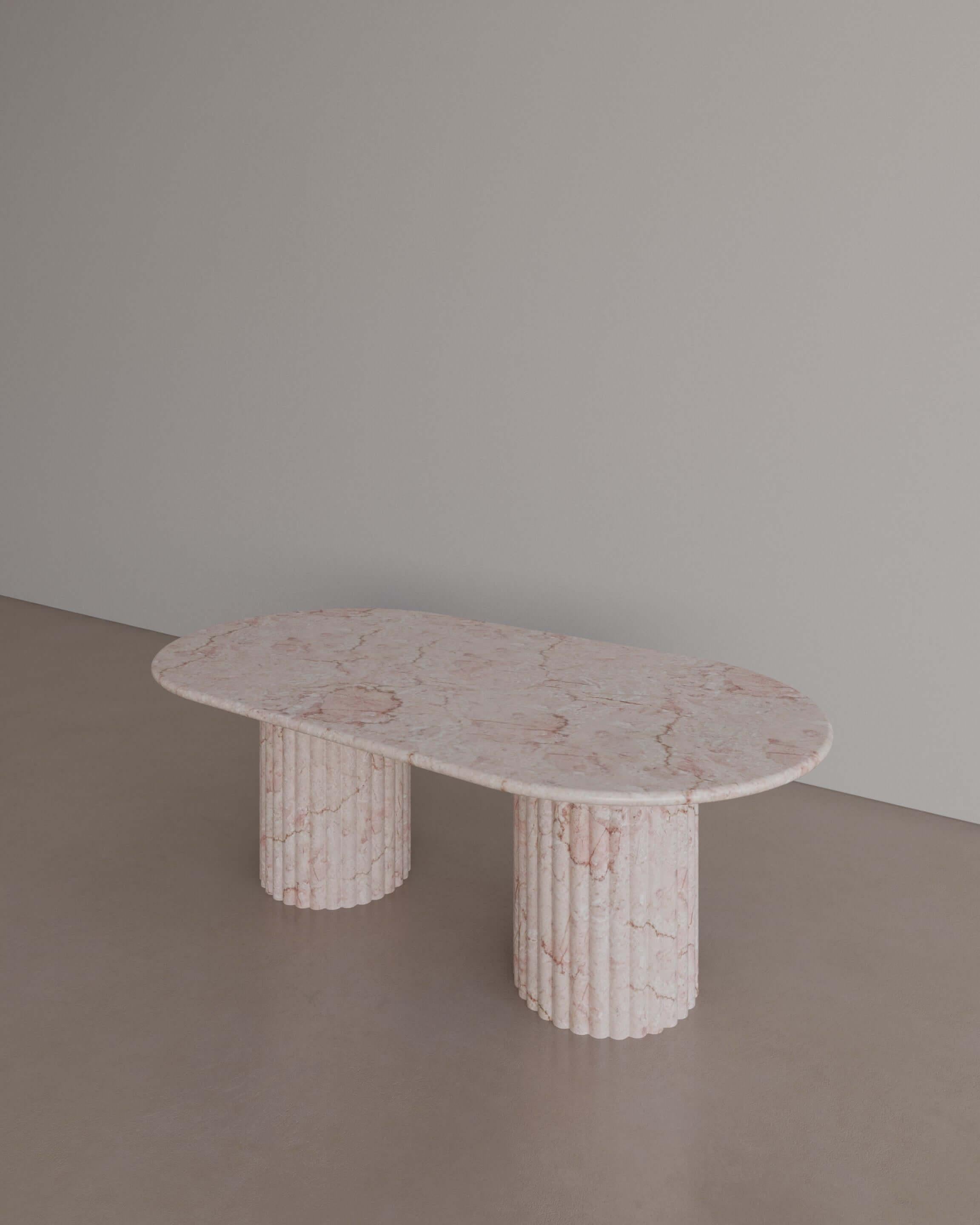 Echoing Roman architecture, The Essentialist brings you The Antica Coffee Table in Afshar Pink Marble. Embodying permanence in its veneration of whole, natural stone. A sensuous oval of stone with smooth bullnose edges rests on two generously