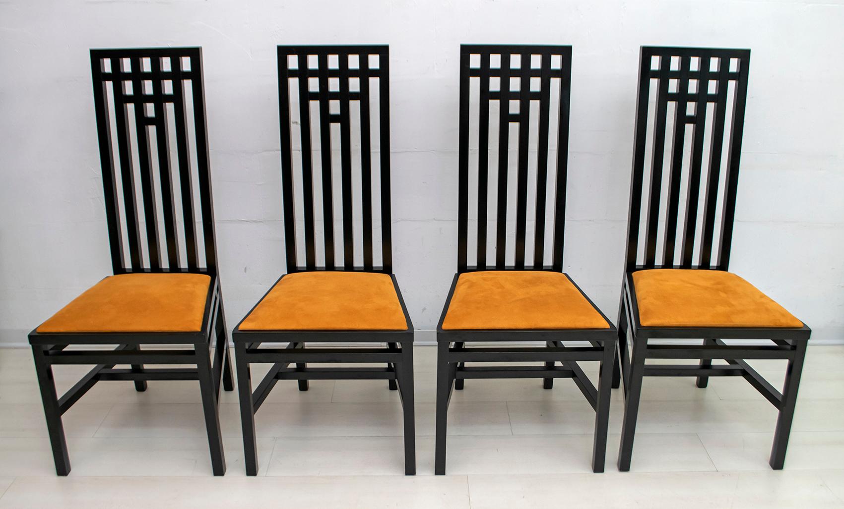 In the style of the Scottish architect Charles Rennie Mackintosh. These four chairs, solidly constructed of black lacquered wood, with orange microfiber upholstery, late 1970s.