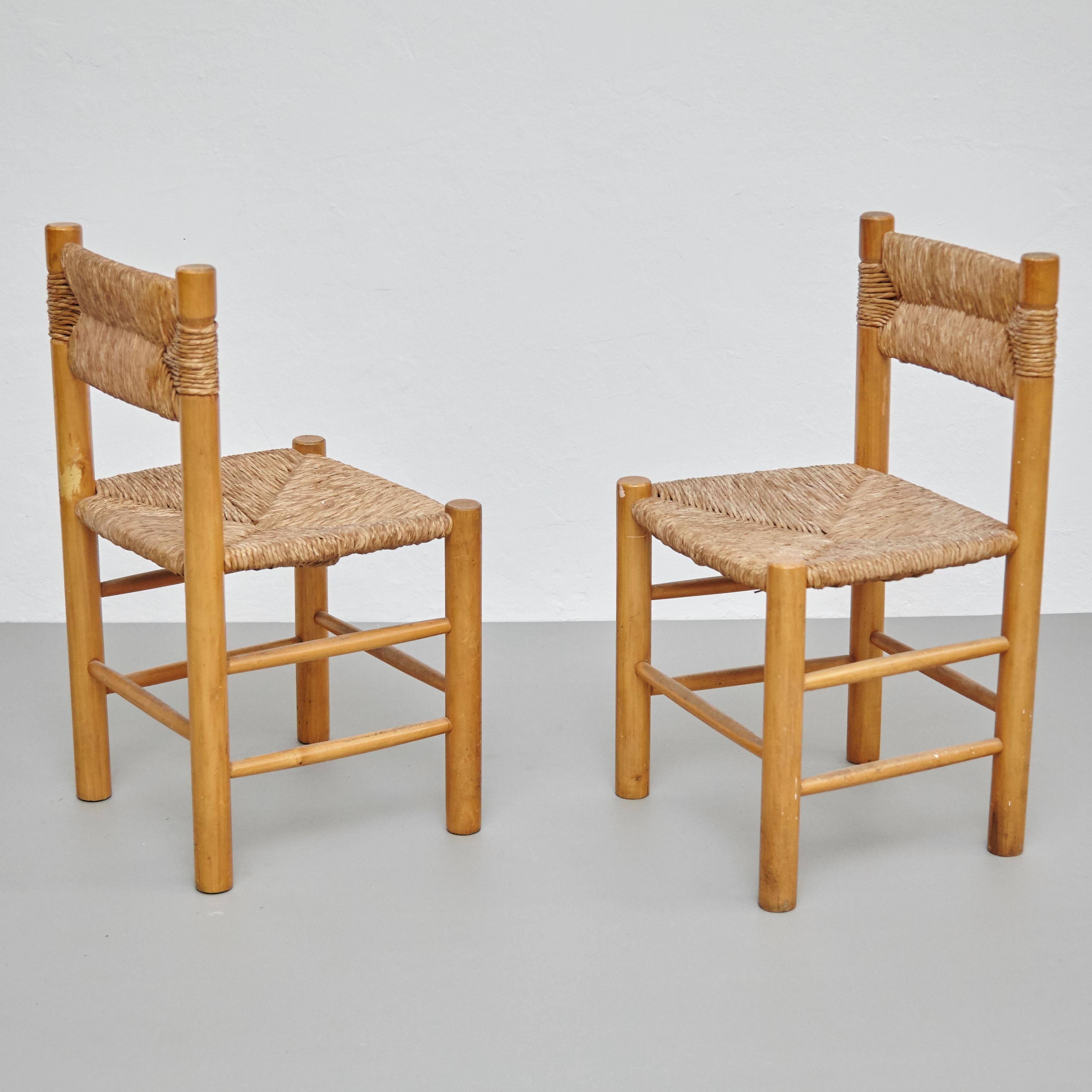 Set of 2 Mid-Century Modern wood rattan French chairs, circa 1950.
By unknown manufacturer, France.

In original condition, with minor wear consistent with age and use, preserving a beautiful patina.

Materials:
Wood
Rattan

Dimensions:
D