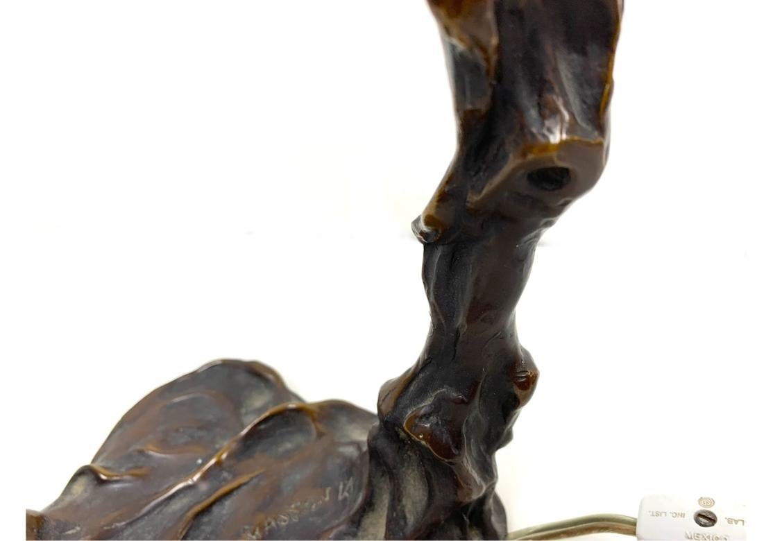 After Emil Thomasson bronze art nouveau lamp depicting a nude woman, the Greek goddess Daphne, depicted in repose or mid-transformation into a laurel tree.
The lamp is signed in the mould as shown. Remnants of green felt under the base. Later wired