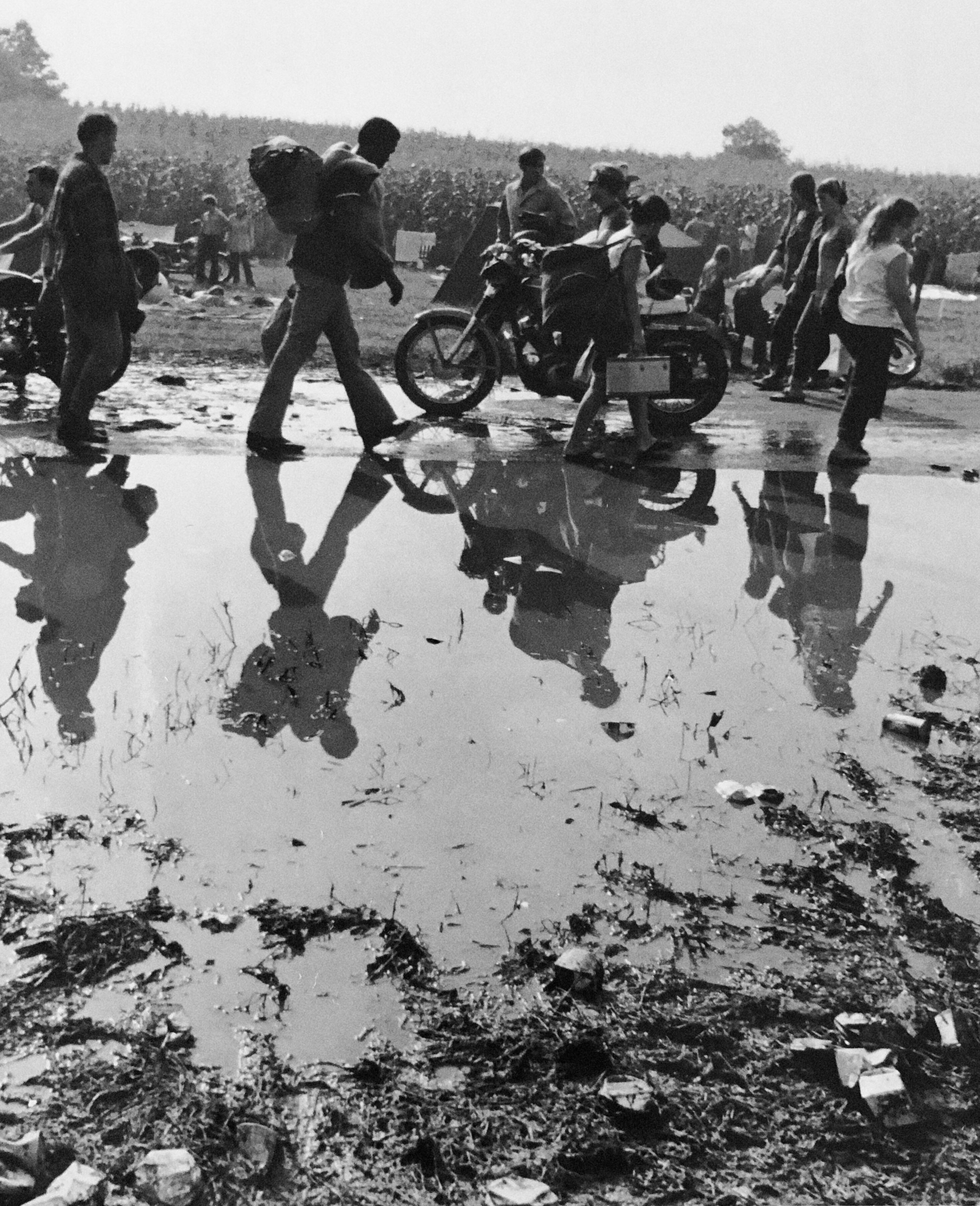 Menschen gehen entlang einer Pfütze in Woodstock in Bethel NY 1969
Der Fotograf ist Fred McDarrah 

Über einen Zeitraum von 50 Jahren dokumentierte McDarrah den Aufstieg der Beat-Generation, die postmoderne Kunstbewegung der Stadt, ihre