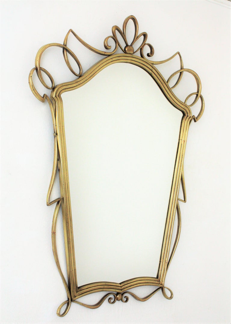Mid-Century Modern polished brass mirror, after Gio Ponti, Italy, 1950s.
It has pure lines and beautiful design with reminiscences of Gio Ponti style.
This elegant wall mirror would be a good choice wherever you place it: Use it in a powder room,