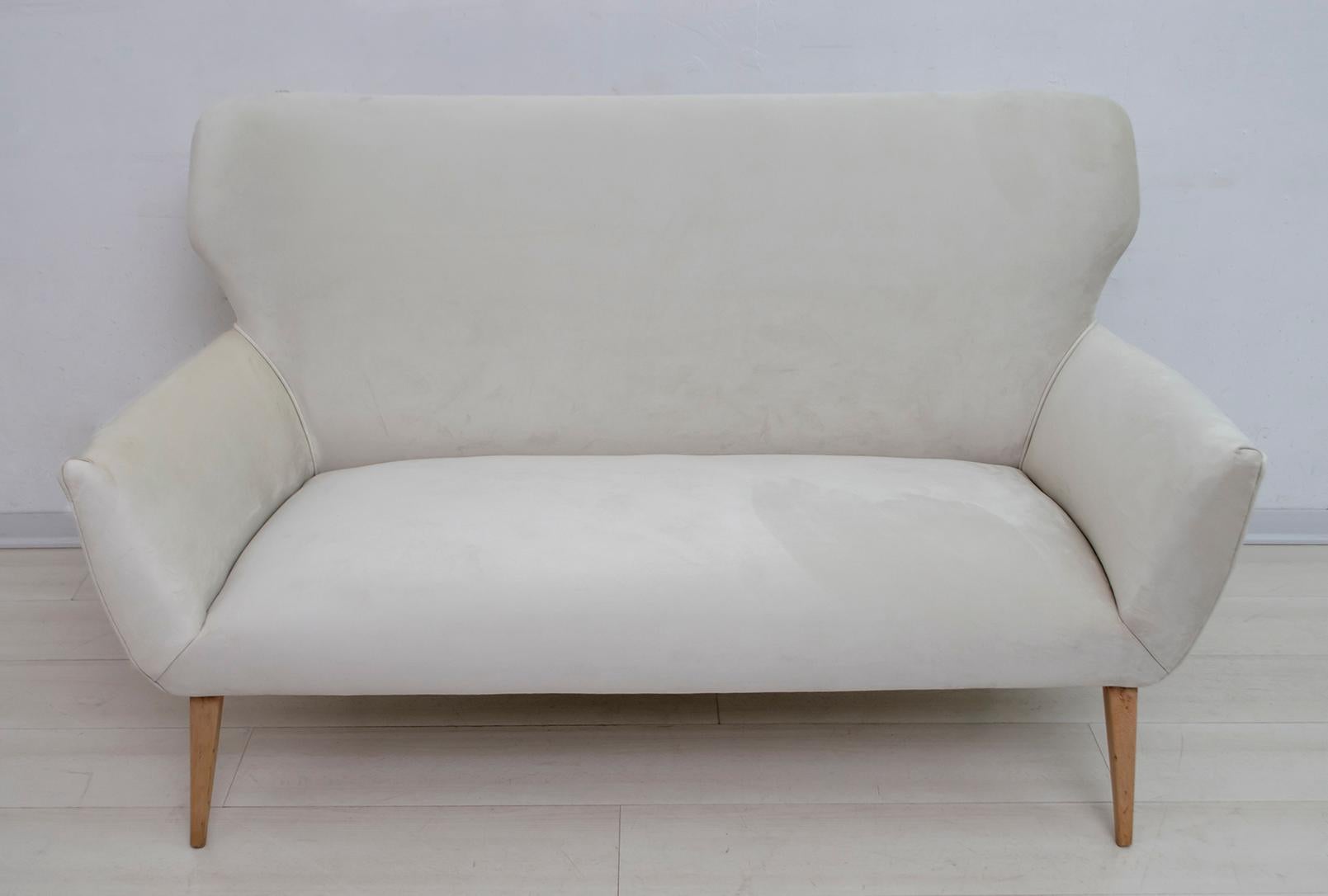 Small sofa in Gio Ponti style Italian production of the 1950s, 
upholstered in cream-colored velvet, feet in natural beech.