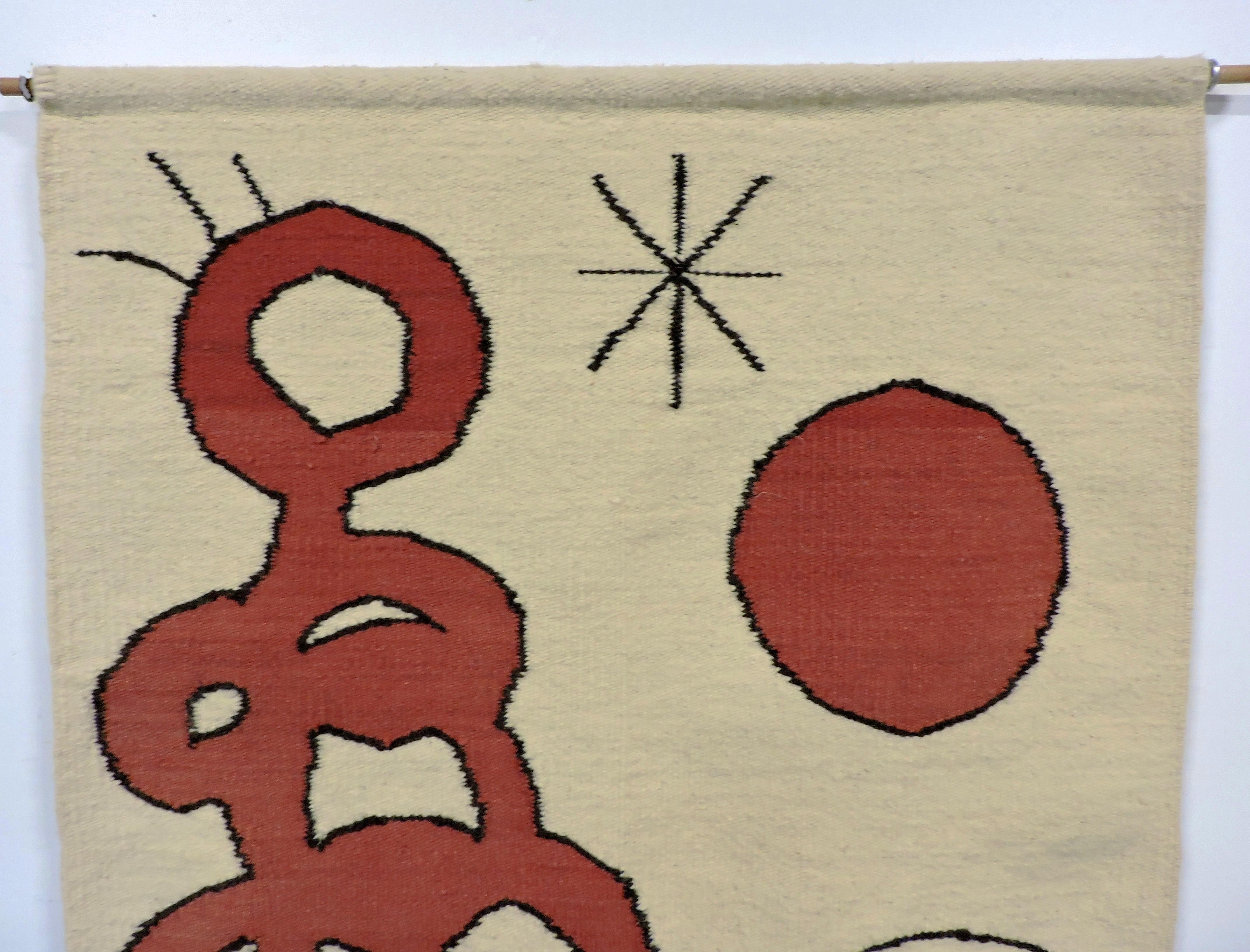 Wonderful handwoven abstract textile art after Joan Miro. This colorful and whimsical tapestry is composed of wool in red, blue and black, with an ivory colored background.