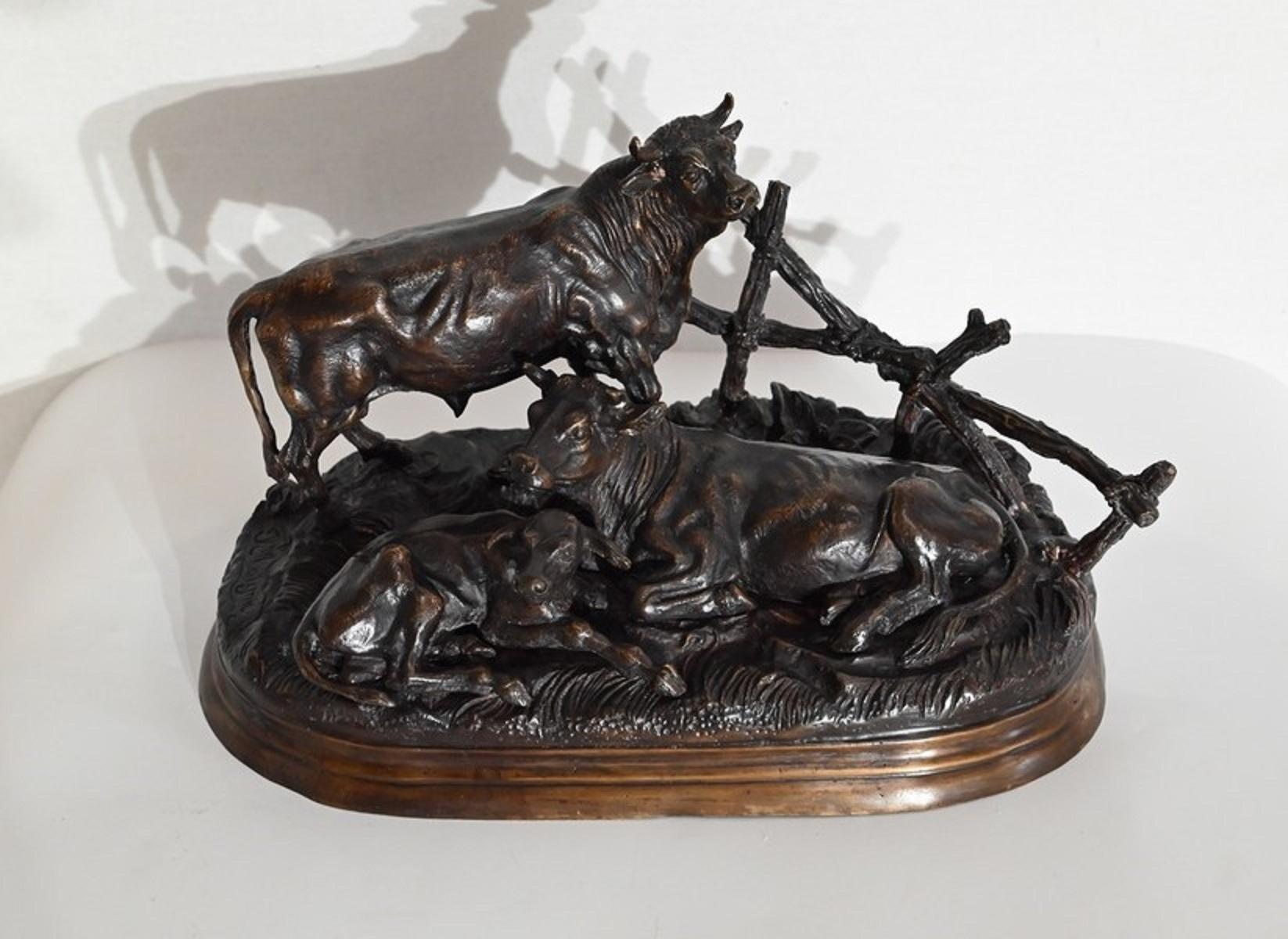 Künstlerisch gestalteter Skulpturentisch mit Dekorationsobjekten, nach Jules Moigniez (Franzose 1835-1894), bronzene Figurengruppe in Form eines Stiers, einer Kuh und eines Kalbes auf naturalistisch modelliertem Grund vor einem Zaun, auf ovalem