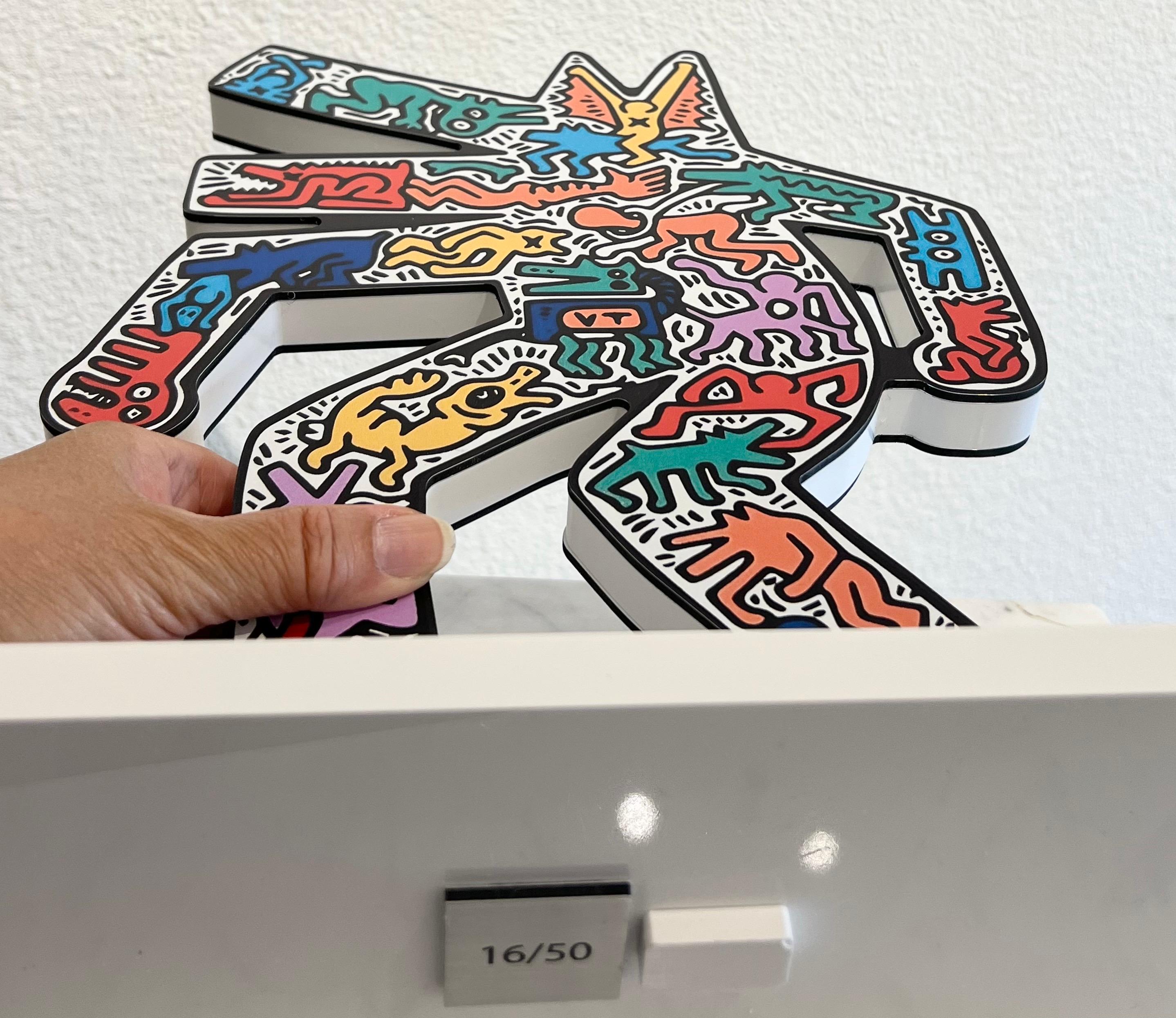 Esta vibrante escultura de resina y plexiglás rinde homenaje al motivo más icónico de Keith Haring: el perro ladrador. El perro ladrador, que apareció por primera vez en sus dibujos del metro de Nueva York a principios de la década de 1980, se