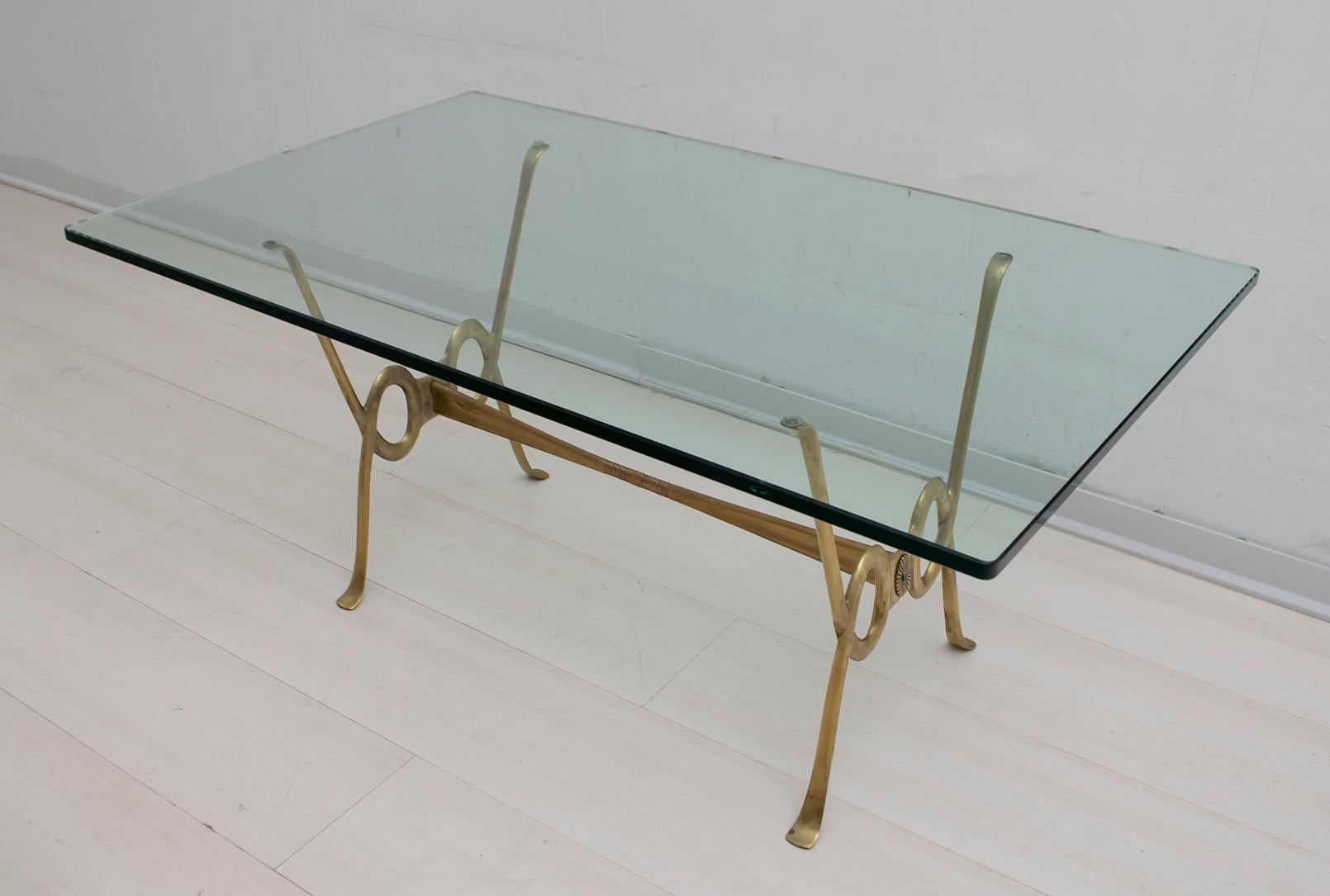 Brass coffee table with thick crystal top, attributed to Osvaldo Borsani, with a pleasant movement of the lines on the sides.
 