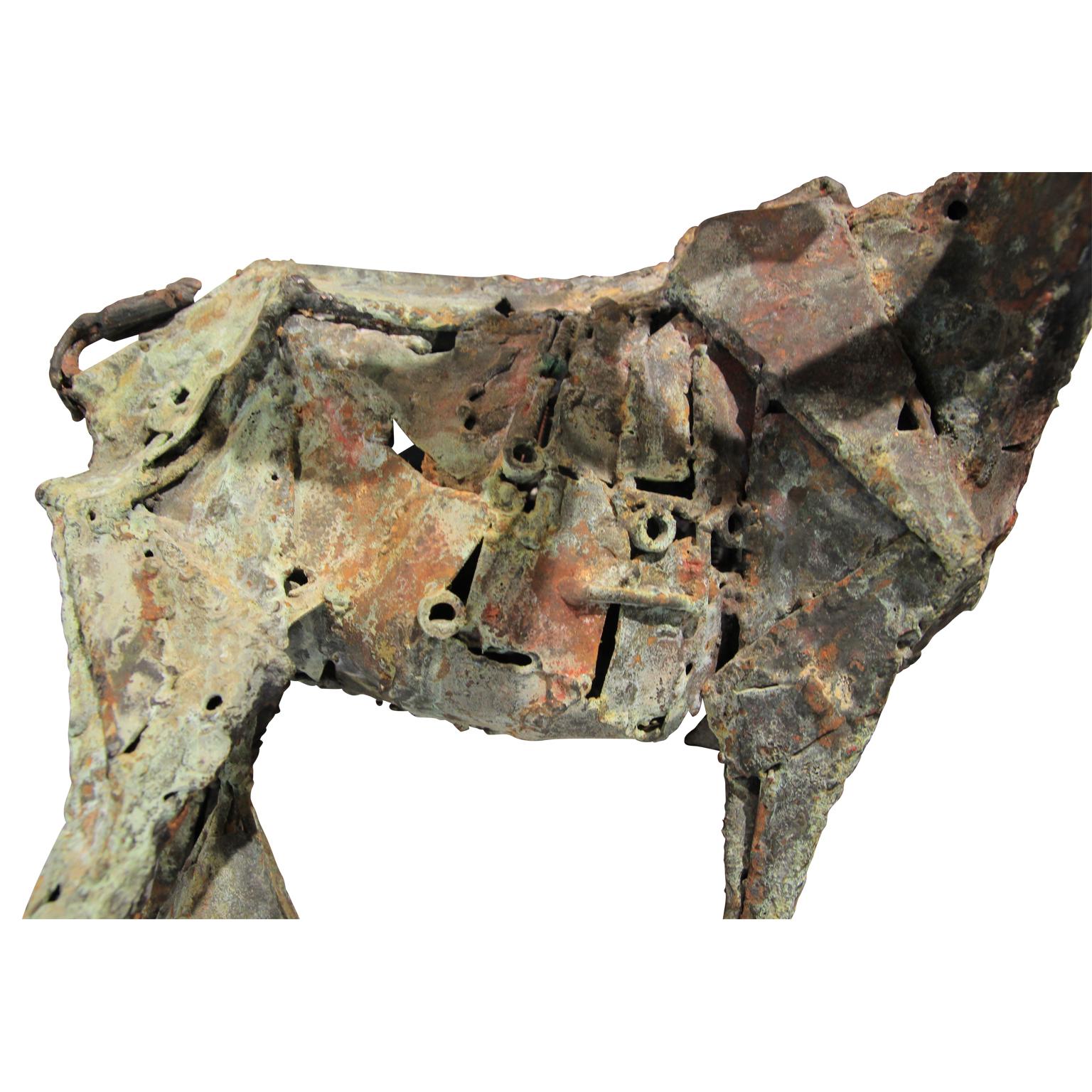Brutalist modern abstract metal sculpture of a fainting goat. The piece is delicately balanced on three legs, capturing the falling motion. It has developed a beautiful green patina with age. Designed in the style of Pablo Picasso's 1950 