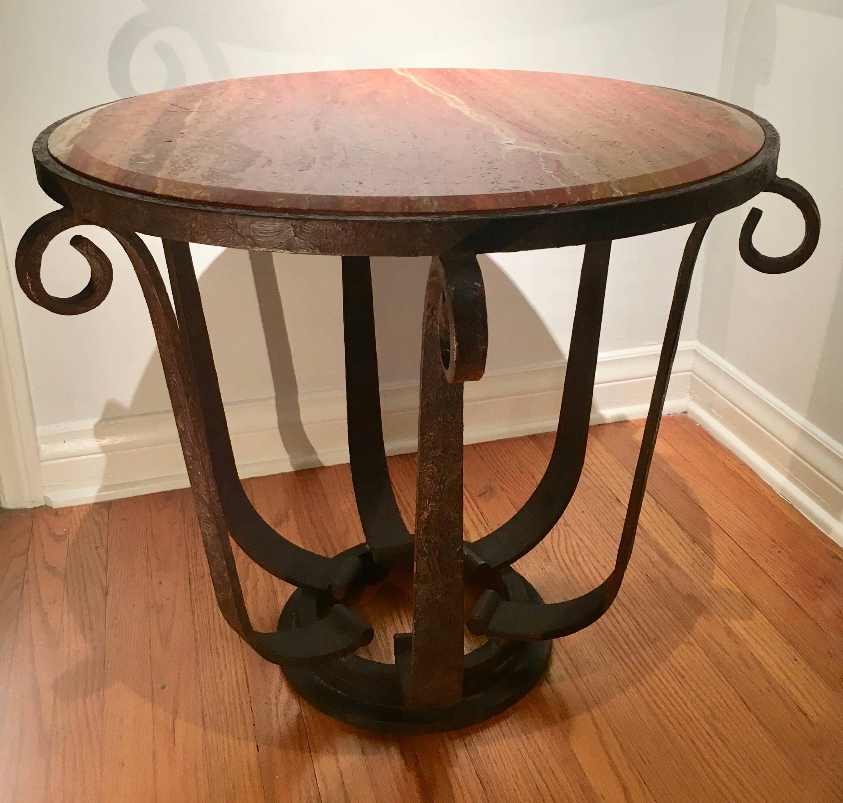 A handsome example after Raymond Subes - variegated and dynamic beveled marble top with well designed wrought iron base - very heavy and stable. Could be used in any room and also suited for exterior use, hand-wrought iron base in natural brownish