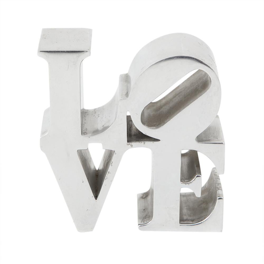 After Robert Indiana Love paperweight. Polished aluminum. Some scratches and signs of wear.