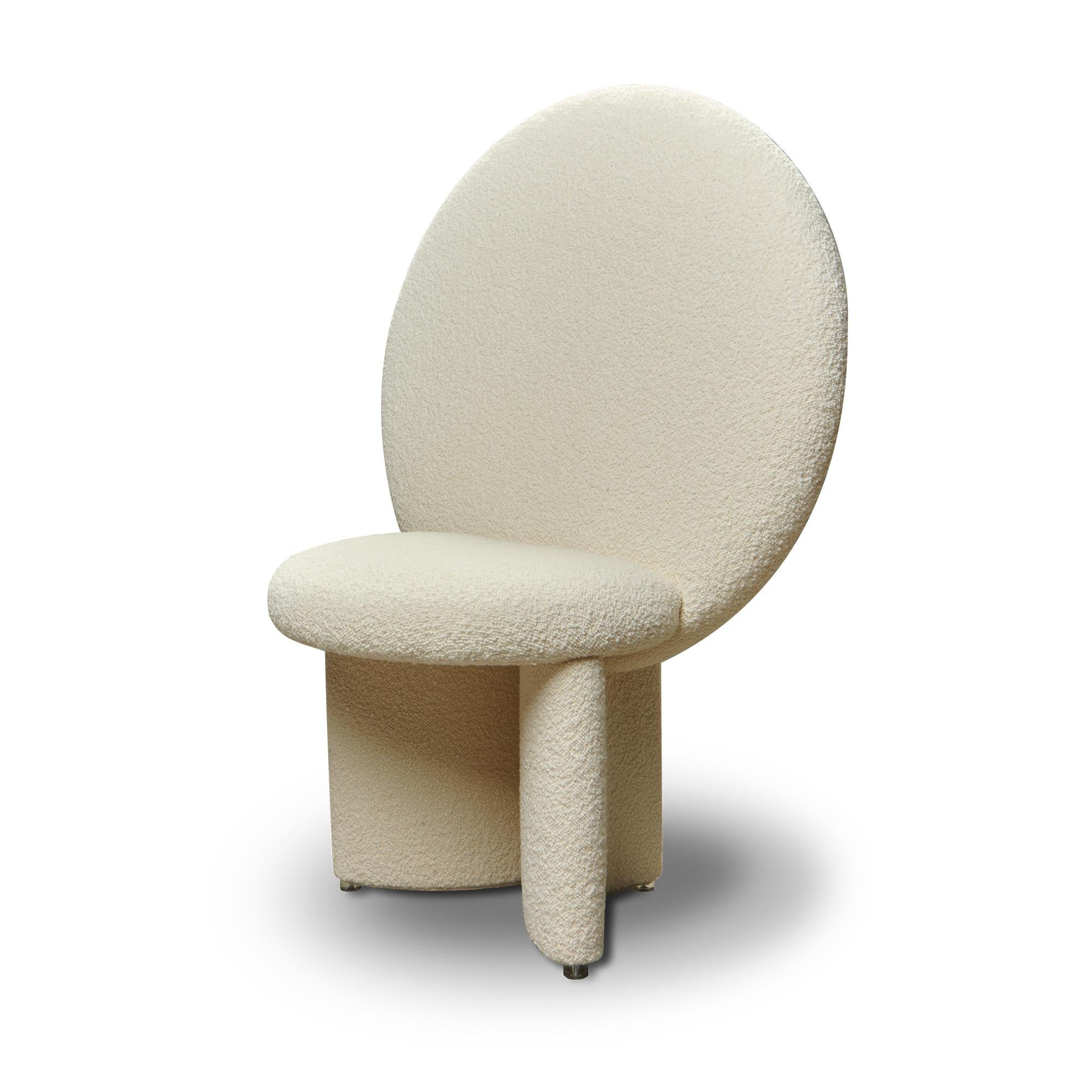 Afternoon Chair has the majesty of a throne, with the huge circular backrest that reaches out and upwards, its legs curve to join the seat at angles. The chair is completely upholstered with soft, textural bouclé fabric.