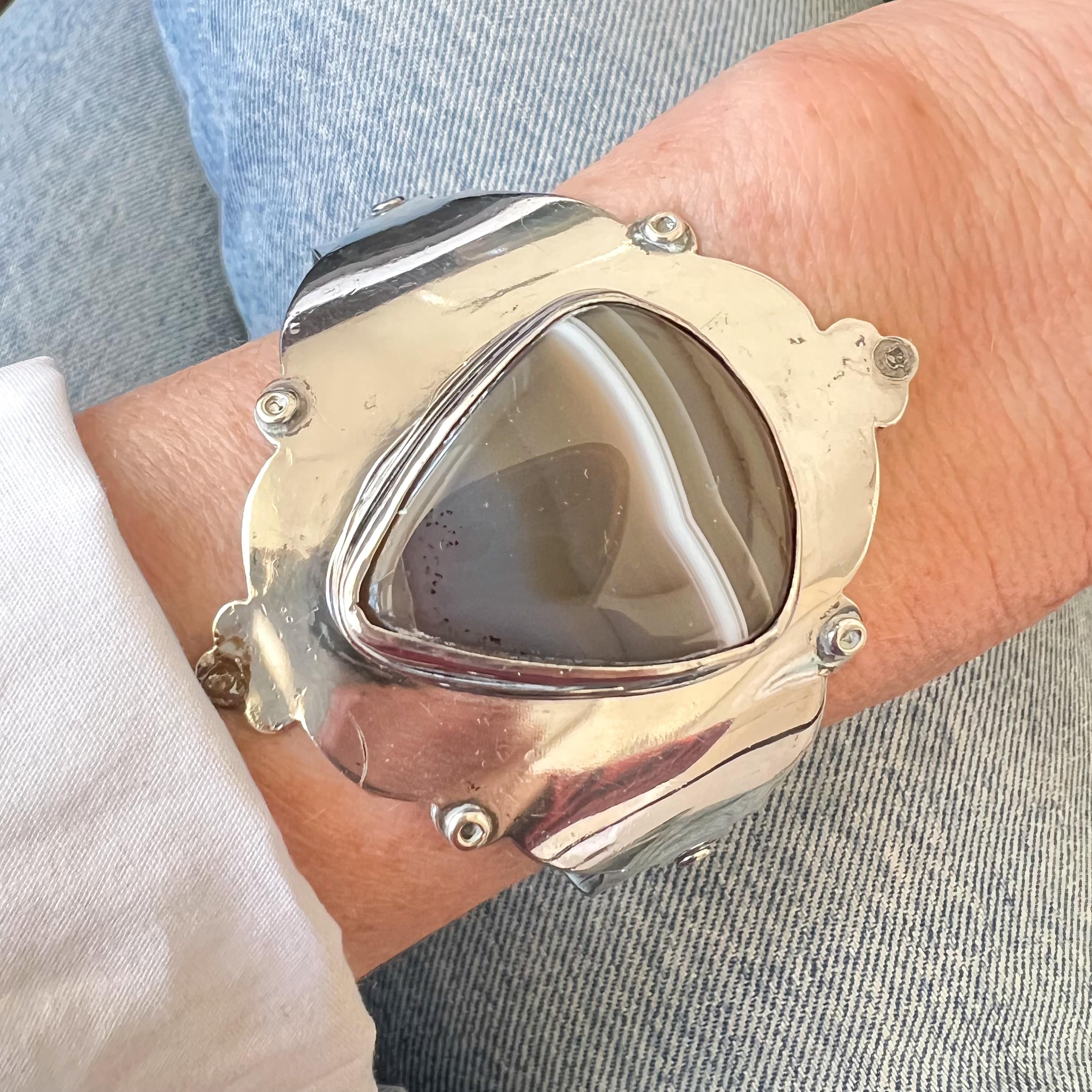 Questo bracciale modernista in argento vintage è un pezzo di ottima fattura che unisce un'eleganza rustica a elementi di design senza tempo. Il punto focale del bracciale è un'impressionante pietra di agata a forma di triangolo con un'esclusiva