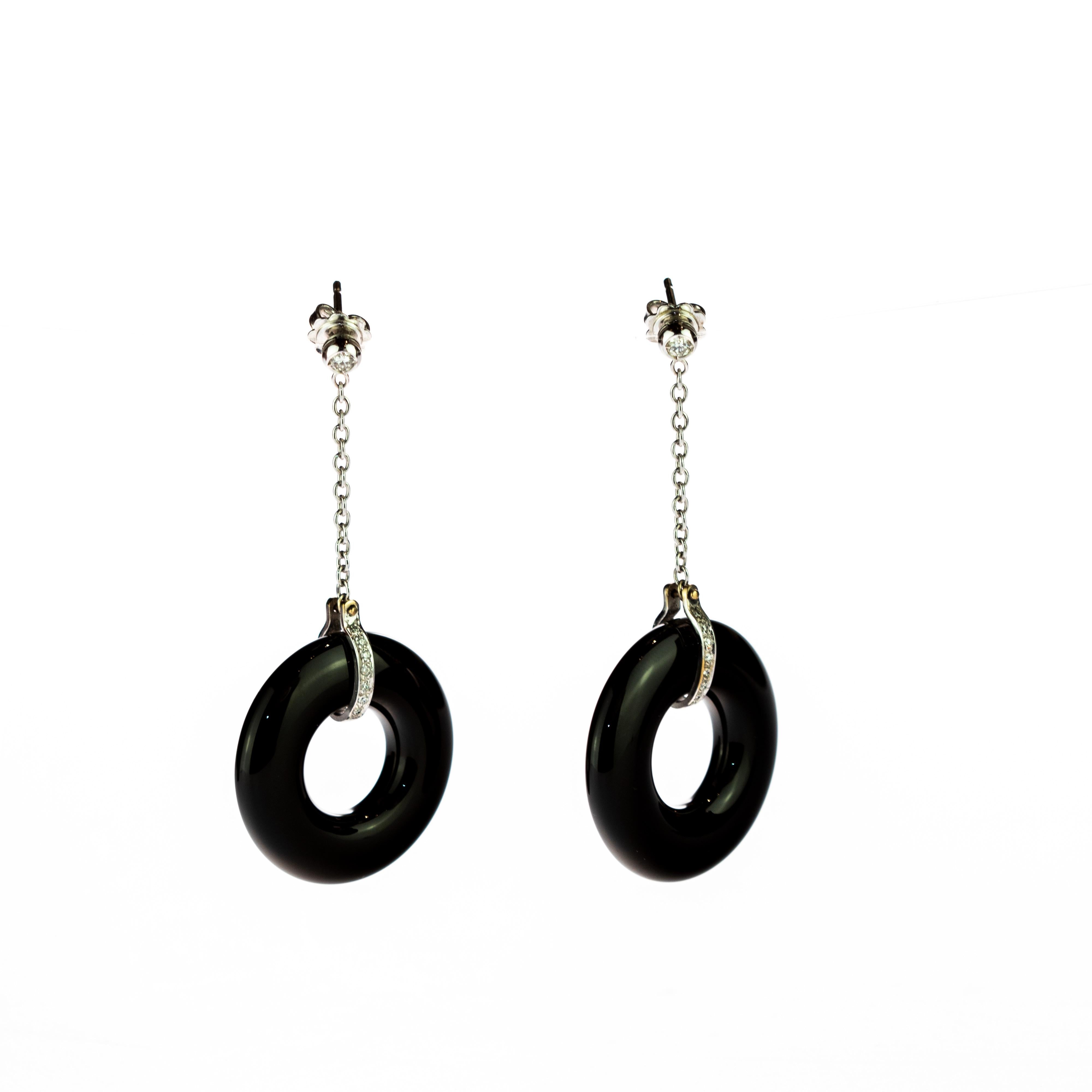 Unique and modern piece designed with a classy and elegant style. Diamond earings with a delicate 18k white gold chain wich ends in a black donut agate gem surounded by more diamonds.

This design is inspired by the winter nights in the north of