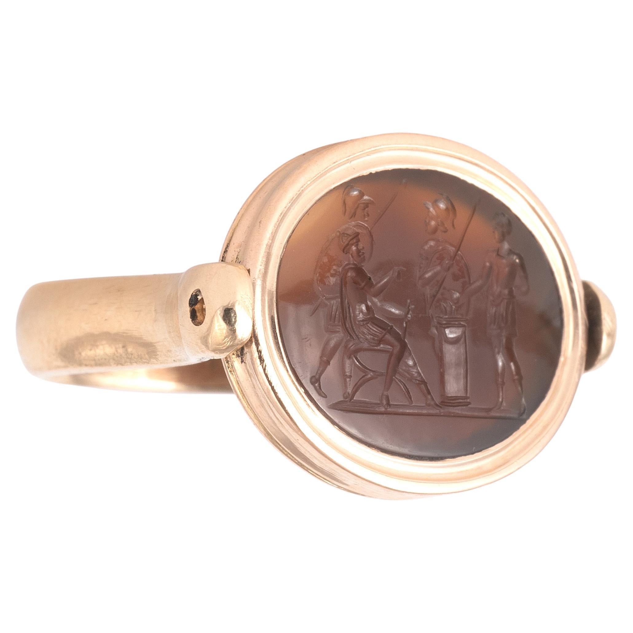 Intaille en agate brune représentant Mucius Scaevola devant Porsenna, posant sa main droite sur un brasero, XVIIe siècle.
Monté sur une bague en or jaune 18 carats de style antique avec une bordure et un anneau cannelés.
Taille supérieure :  23mm x
