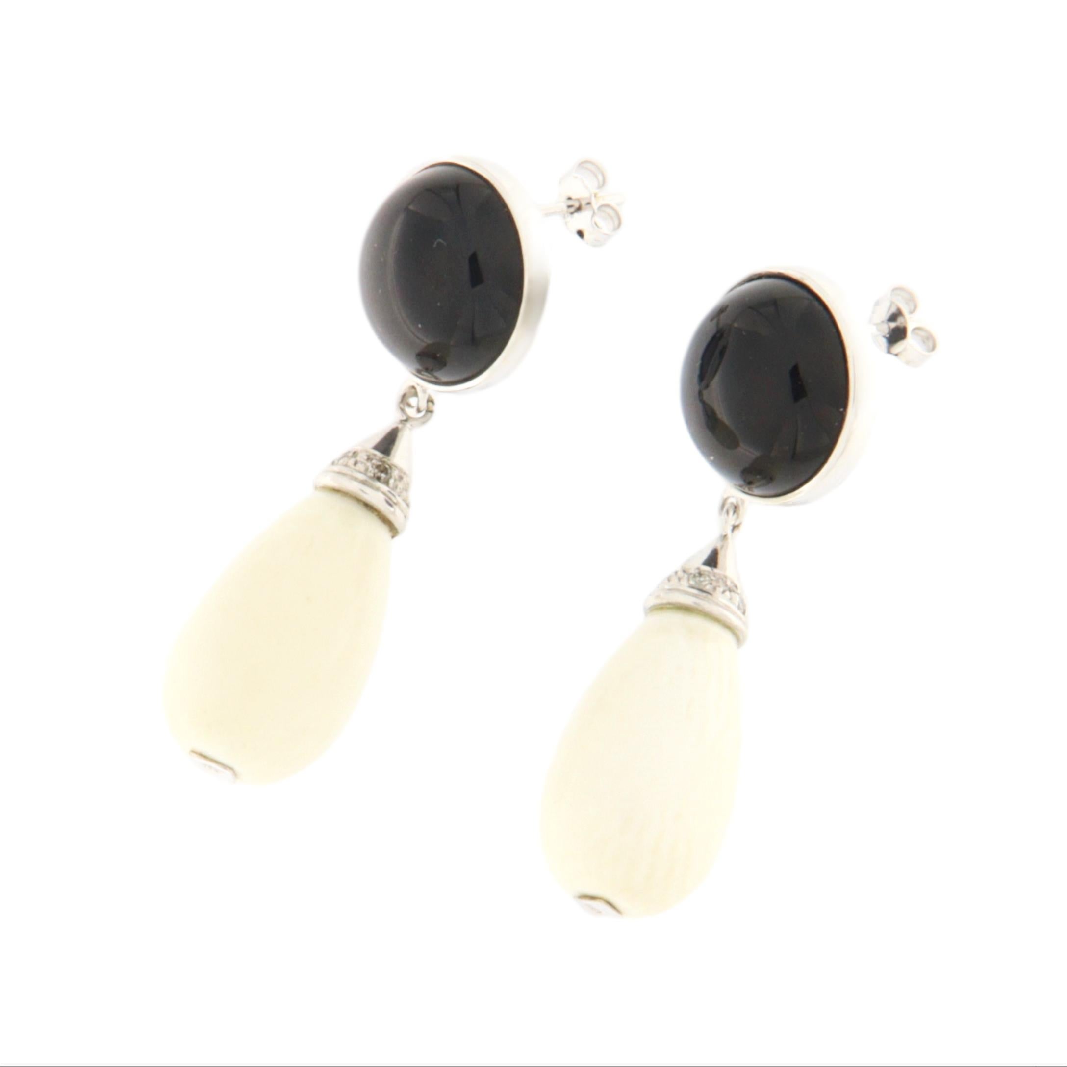 These 18-karat white gold earrings are a refined example of timeless elegance, perfect for those seeking a sophisticated piece that blends tradition and modernity. Each earring features two beautiful cabochons: a glossy black onyx at the top and a