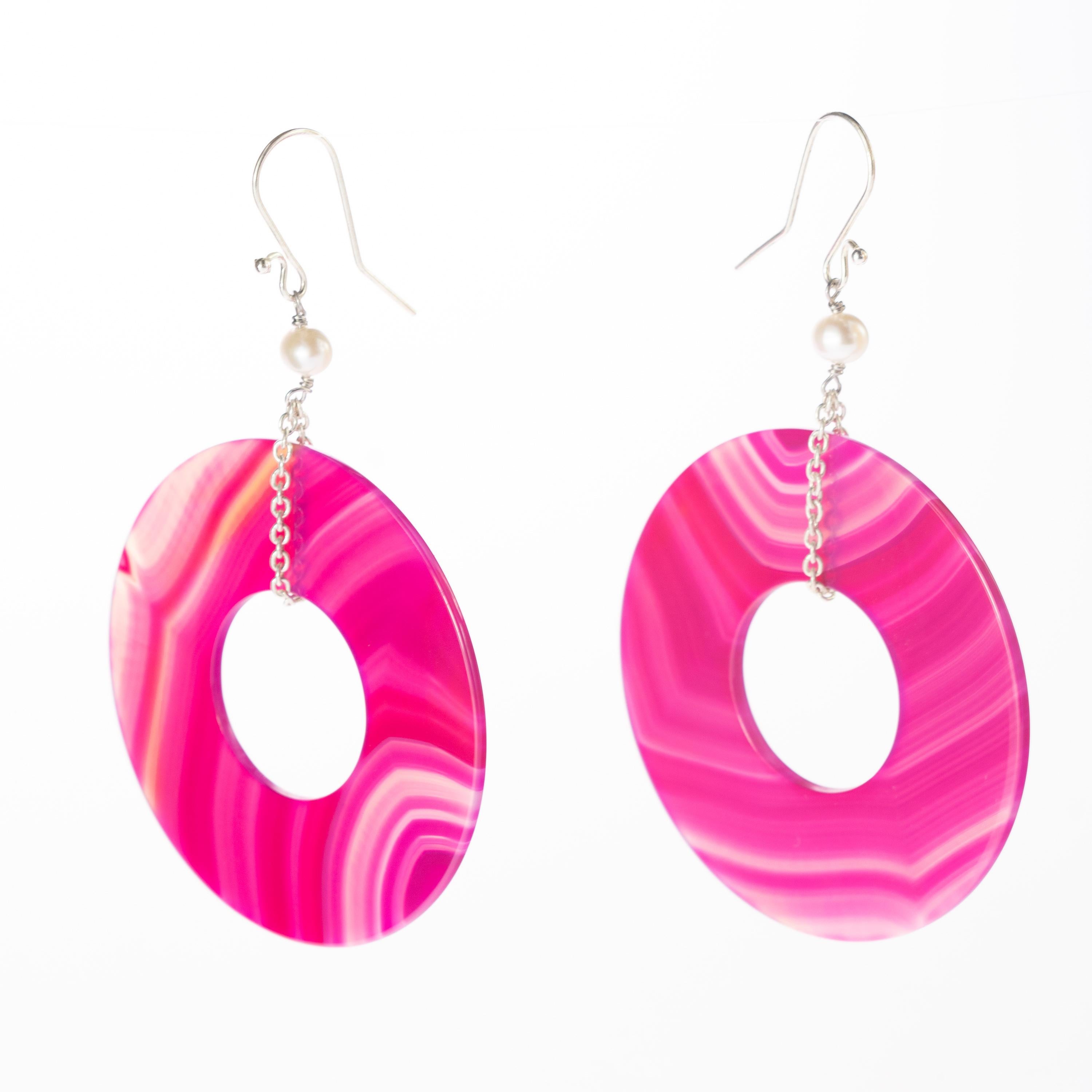 An enchanted round fuchsia agate donut-shaped earrings helded by 925 silver delicate chain with a beautiful pearl. Modern designs full of a vivid color an a voluminous shapes, resulting in bold, free-spirited pieces with a charming elegance.

This