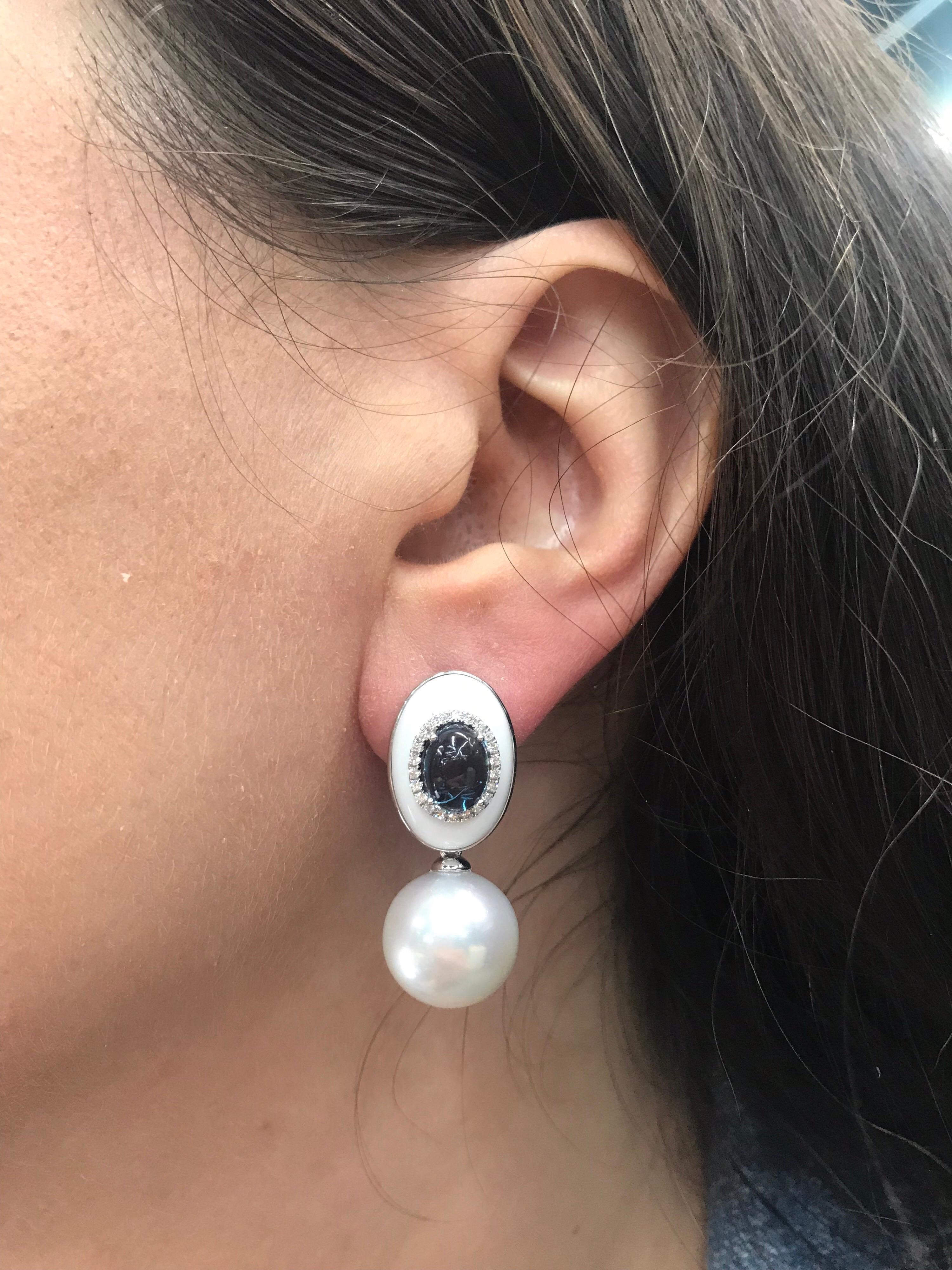 boucles d'oreilles pendantes en or blanc 18 carats, ornées de deux perles des mers du Sud de 13-14 mm, d'une agate et d'une topaze bleue avec un halo de diamants.
Diamants : 0.21 CT
Topaze bleue : 3.50 CT