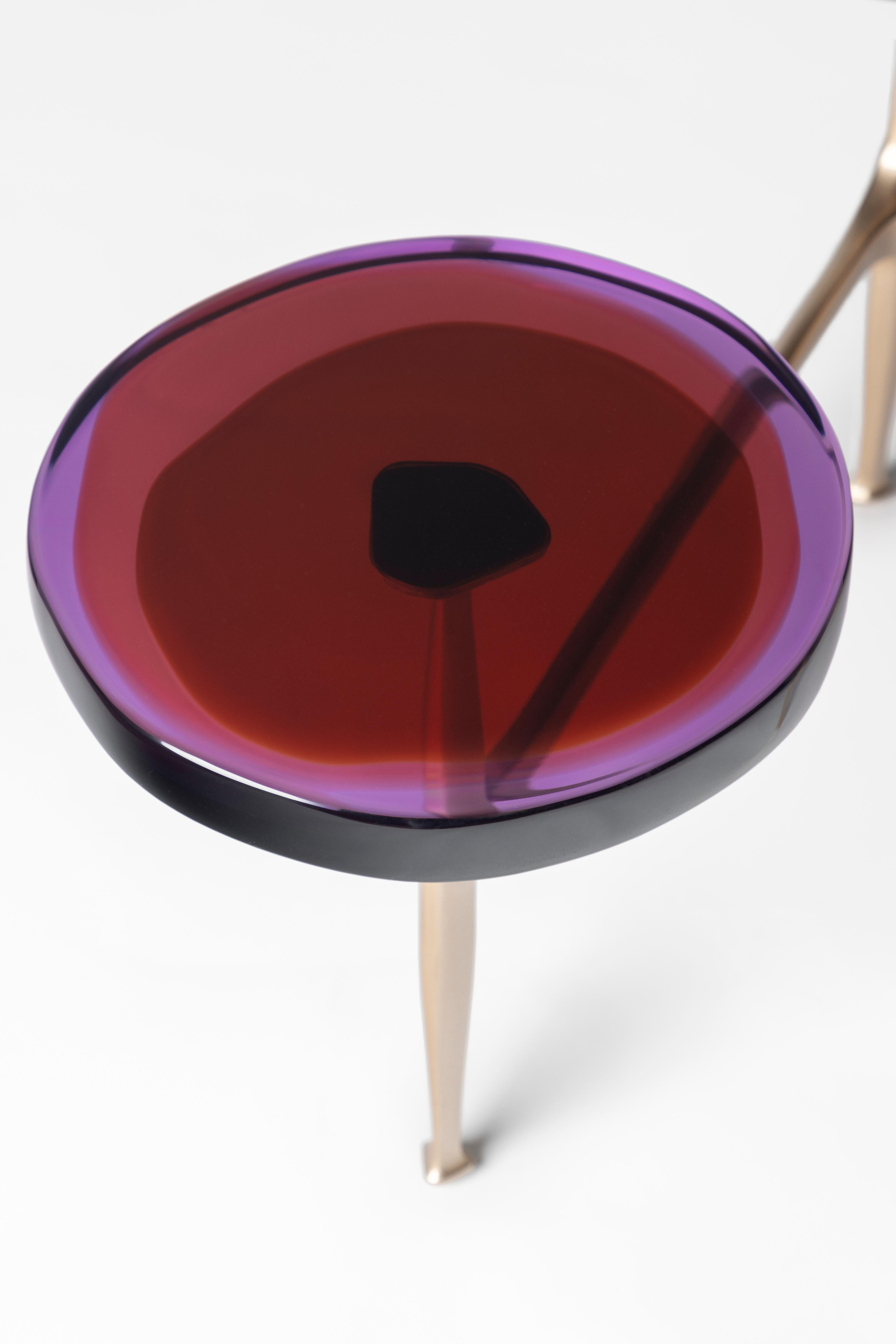 Des grappes de fleurs sauvages ont inspiré la série de tables basses multi-tops Agatha, avec ses formes organiques et ses teintes irisées. Les plateaux circulaires irréguliers en résine époxy transparente sont encastrés dans un cadre en bronze à