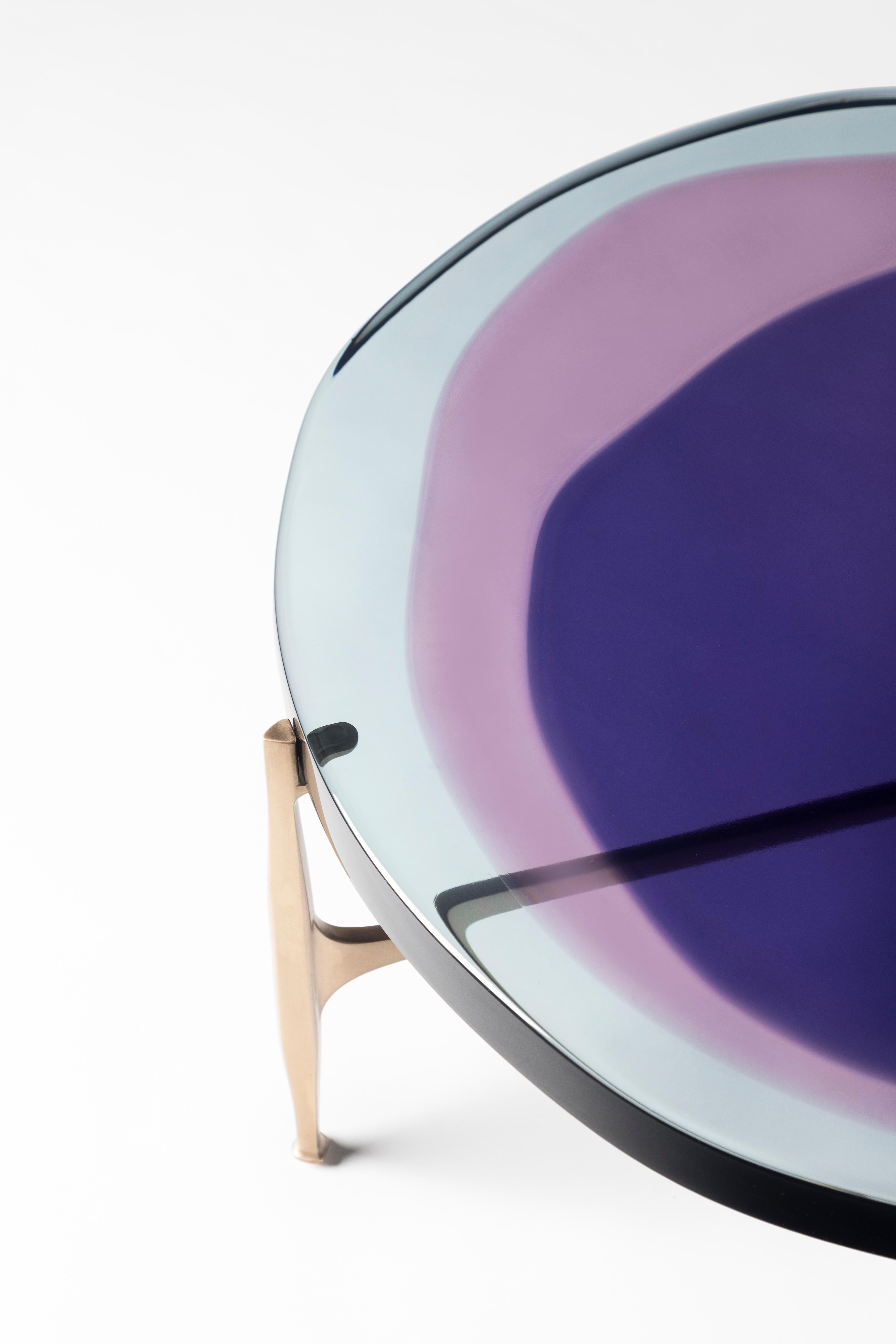 La série de tables basses Agatha est animée par un plateau circulaire irrégulier en résine époxy transparente qui entretient un dialogue avec la lumière. Les couleurs vibrantes sont coulées en plusieurs couches pour créer un composé profond et