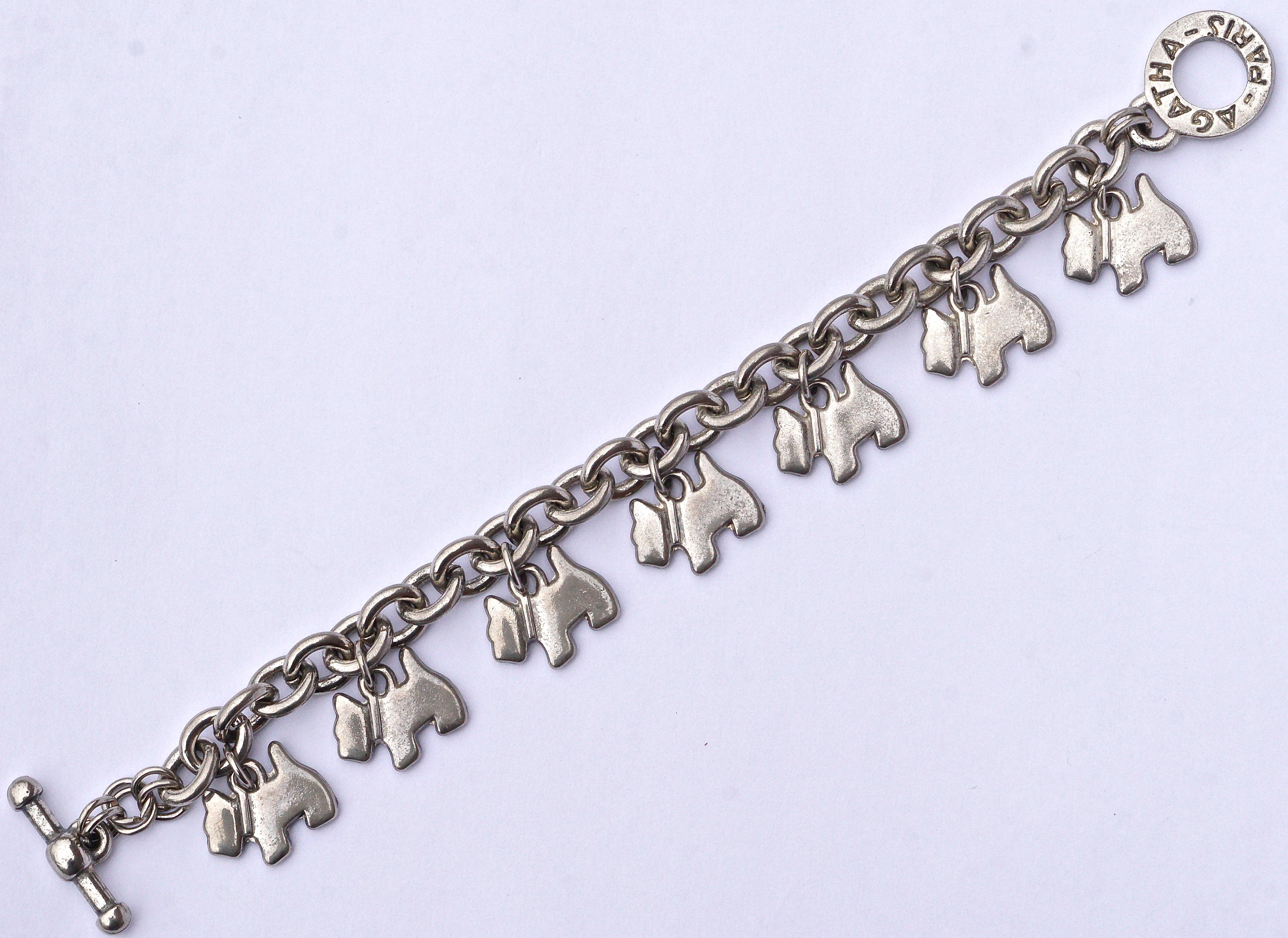 Bracelet Agatha Paris en argent avec un fermoir à bascule:: portant l'emblème du chien écossais Agatha:: vers les années 1980. Le bracelet en chaîne est épais et comporte sept charmantes breloques en forme de chien Scottie. Longueur de 20::5 cm /