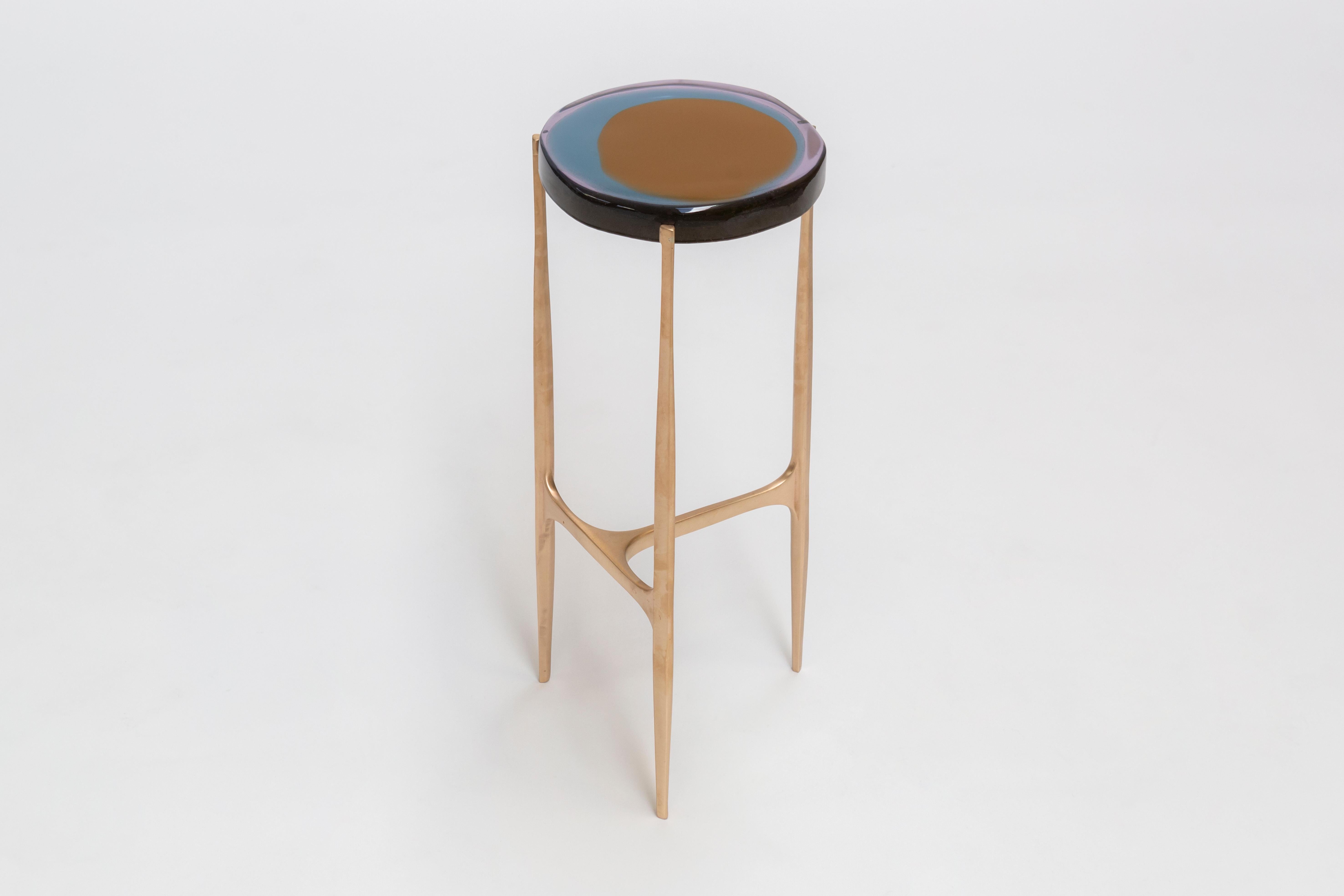 Agatha coffee table series is enlivened by an irregular circular top in transparent epoxy
resin that holds a dialogue with light. The vibrant colors are poured in several layers
to create a deep and fluid compound, embedded in a matte-effect bronze