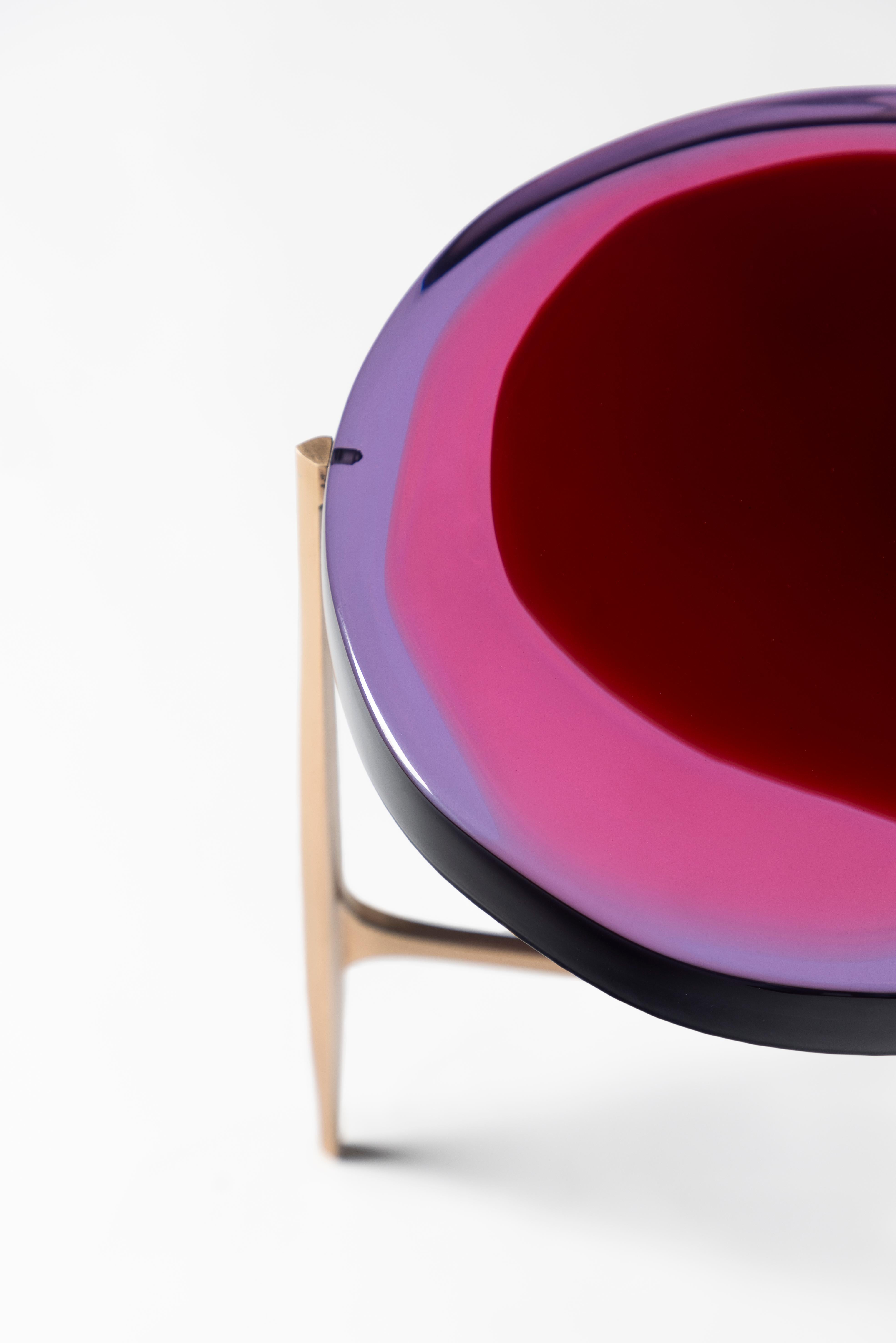 Agatha coffee table series is enlivened by an irregular circular top in transparent epoxy
resin that holds a dialogue with light. The vibrant colors are poured in several layers
to create a deep and fluid compound, embedded in a matte-effect bronze