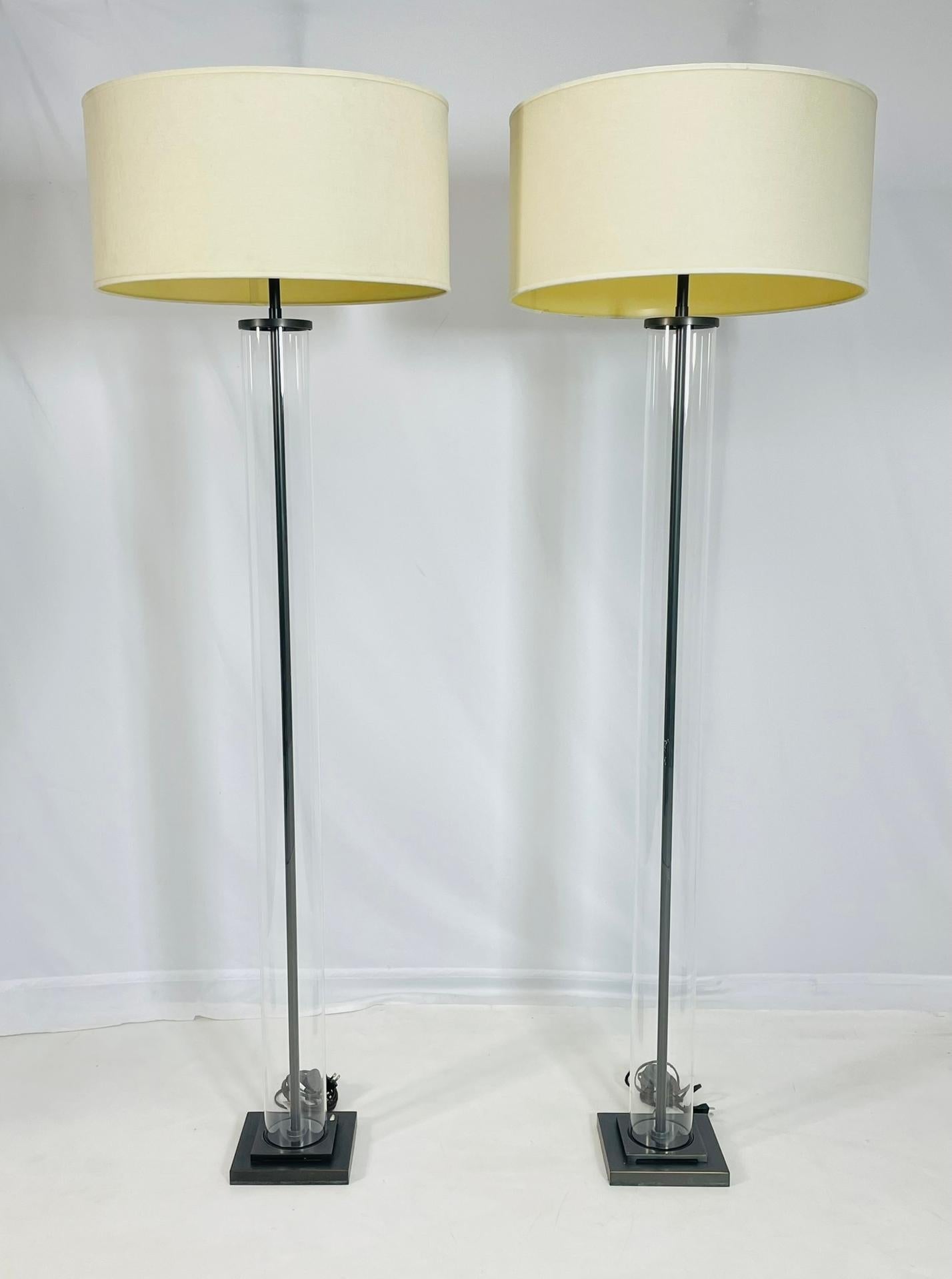 Illuminate your space with sophistication and style with these Aged Brass & Glass Cylinder Floor Lamps by Restoration Hardware. Made in 2015, these timeless pieces feature a sleek aged brass base paired with a stunning glass cylinder body. The lamps
