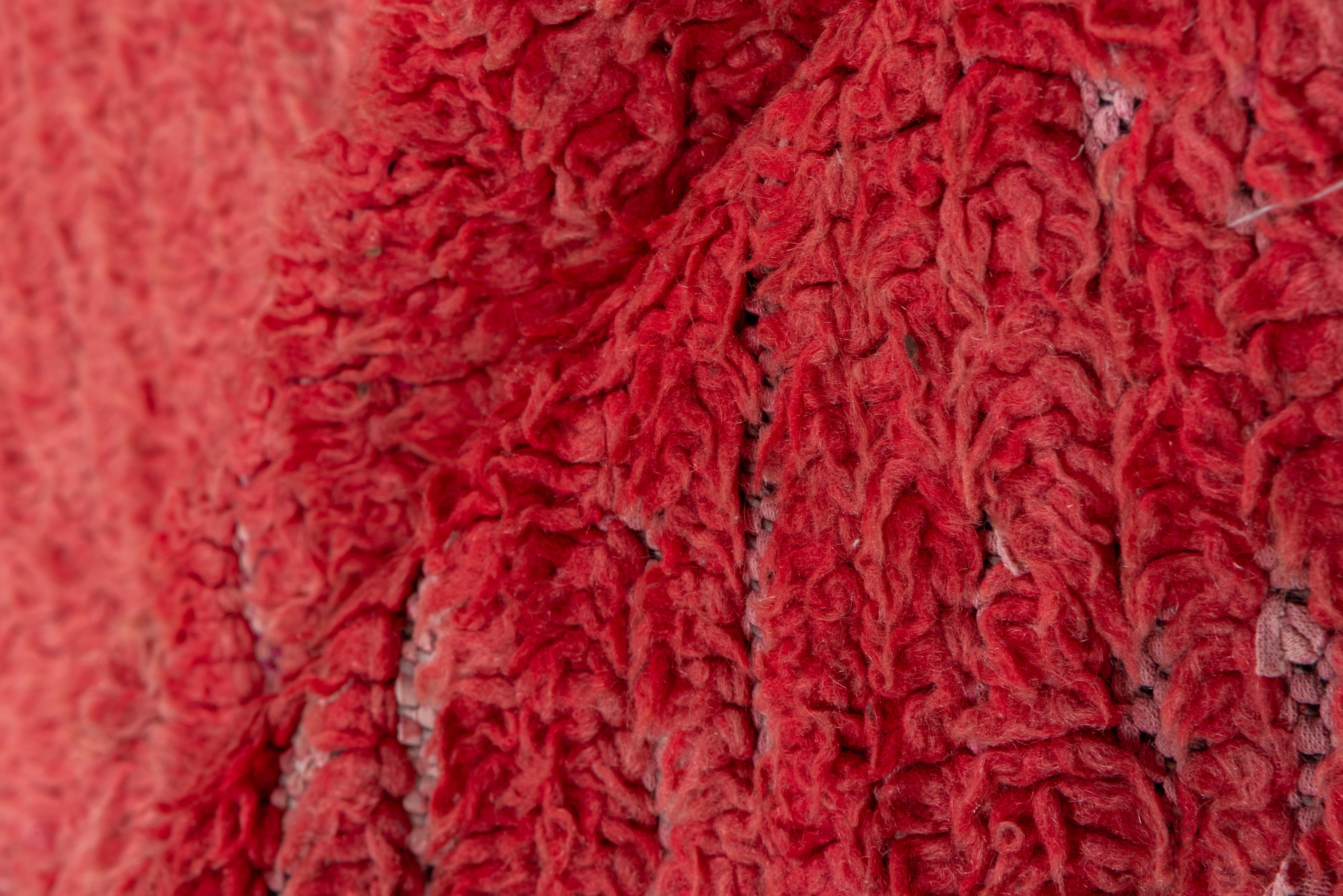 Questo delicato runner in un vivace rosso mostra i segni dell'usura pur mantenendo la sua tinta originale. 