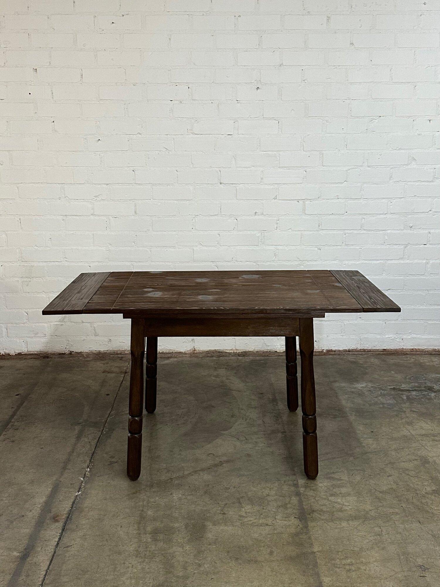 W56 W44 D30 H30 KC25

Structurally sound and sturdy aged pine dining table. Surface has been cleaned and refinished in a dark walnut. Table extensions easily fold down with a wooden rail underneath that slide forward and backwards.

