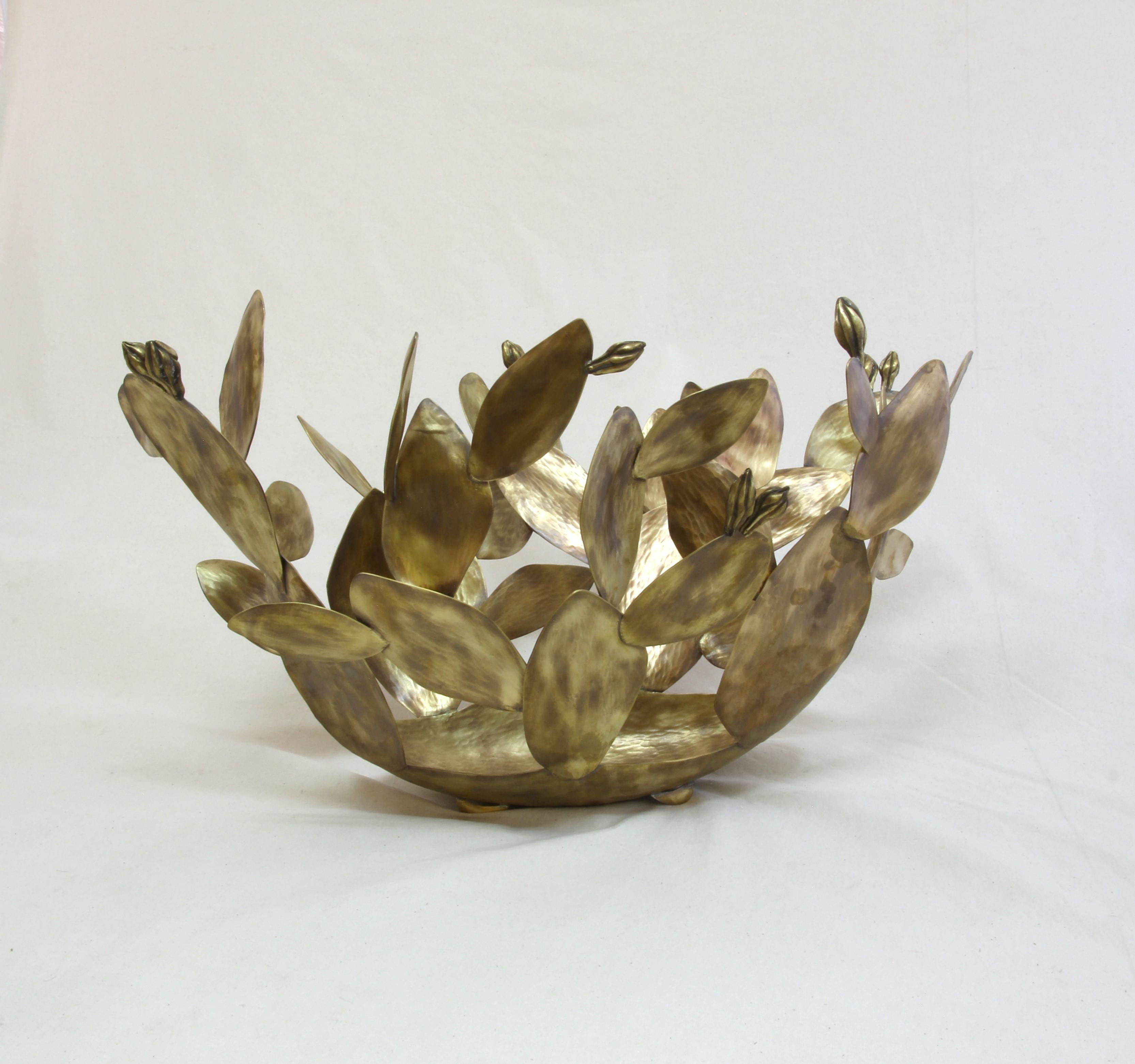 Inspired by the wonderful shapes of the desert, this organic centerpiece is made out of aged Tumbaga.
100% hand made by expert craftsmen, each sheet of metal is hand hammered, cut and twisted using metal and wood as a last to give each twist and