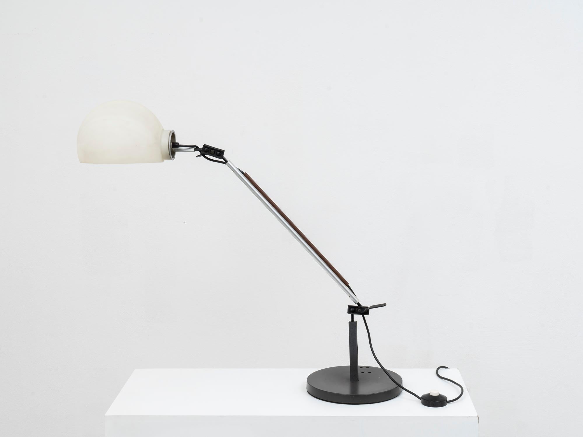 This desk lamp was first issued by Artemide in 1976, as a part of the combinable system crated by the Italian designers Enzo Mari and with Giancarlo Fassina. This system was composed by modular elements that could be freely combined to create