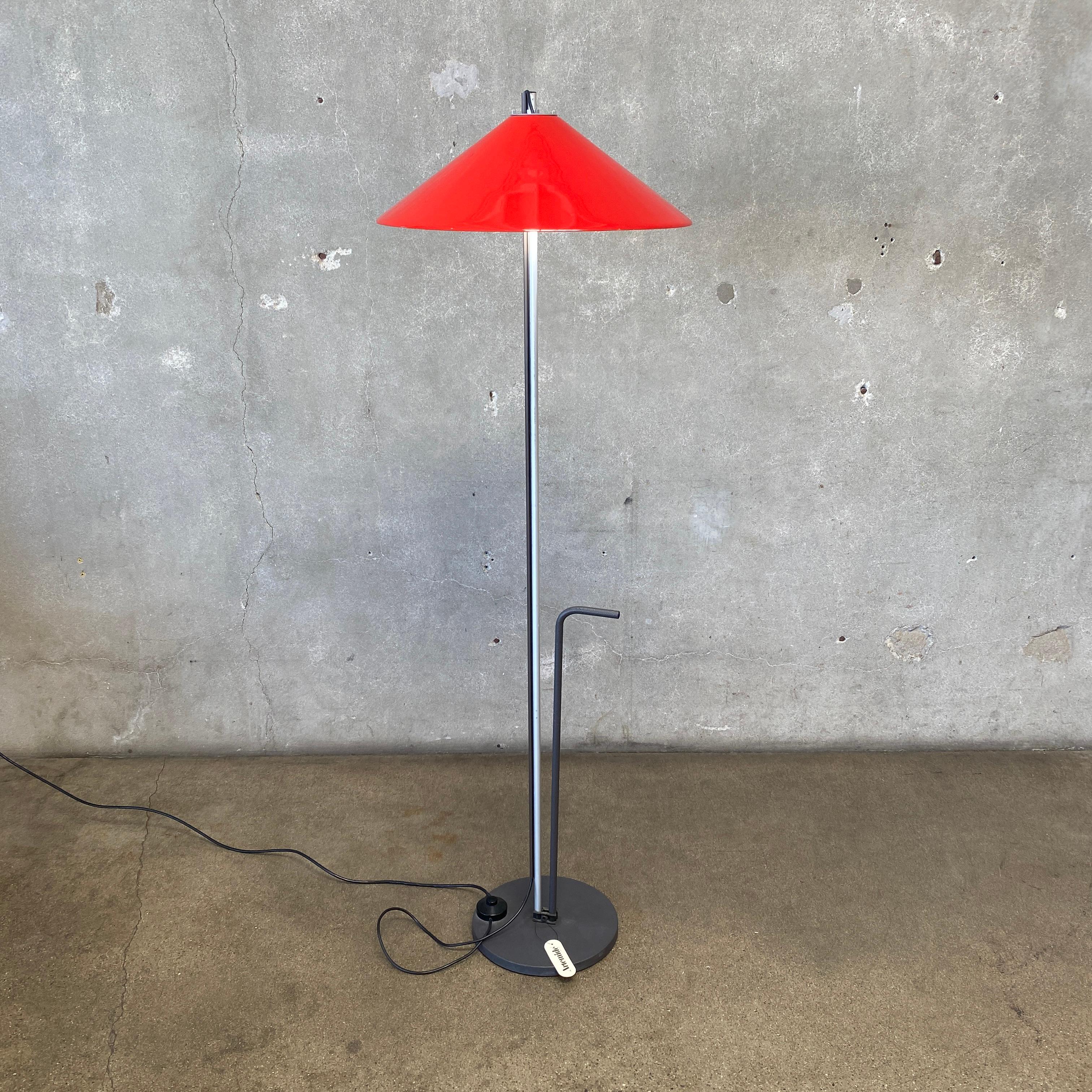 Questa è una lampada da terra Aggregato Terra, disegnata da Enzo Mari e Giancarlo Fassina per Artemide nel 1974. La lampada è stata prodotta in Italia e presenta una base e uno stelo in metallo e un paralume in plexiglass rosso brillante. Ha una