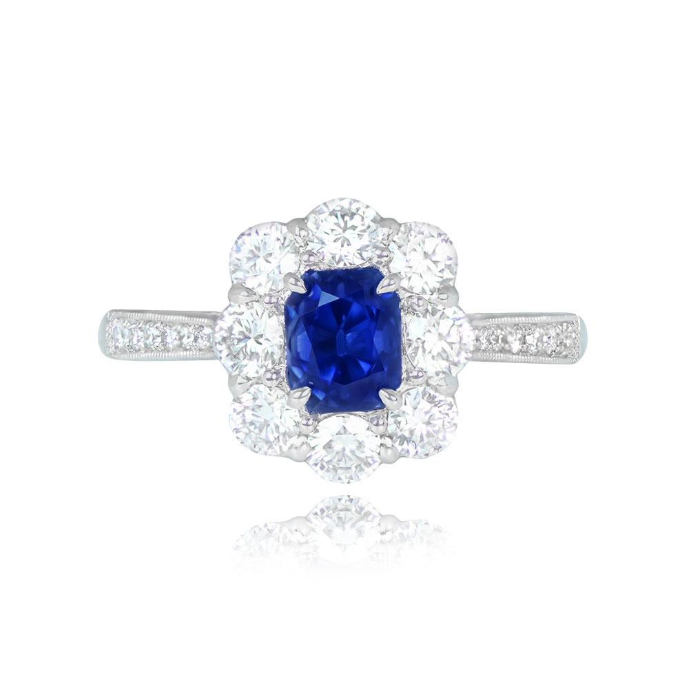 This exquisite ring highlights a 1.45-carat cushion-cut Kashmir sapphire, certified by AGL and completely untreated. The sapphire is elegantly set in prongs and enhanced by a halo of round brilliant cut diamonds. Additional diamonds adorn the ring's