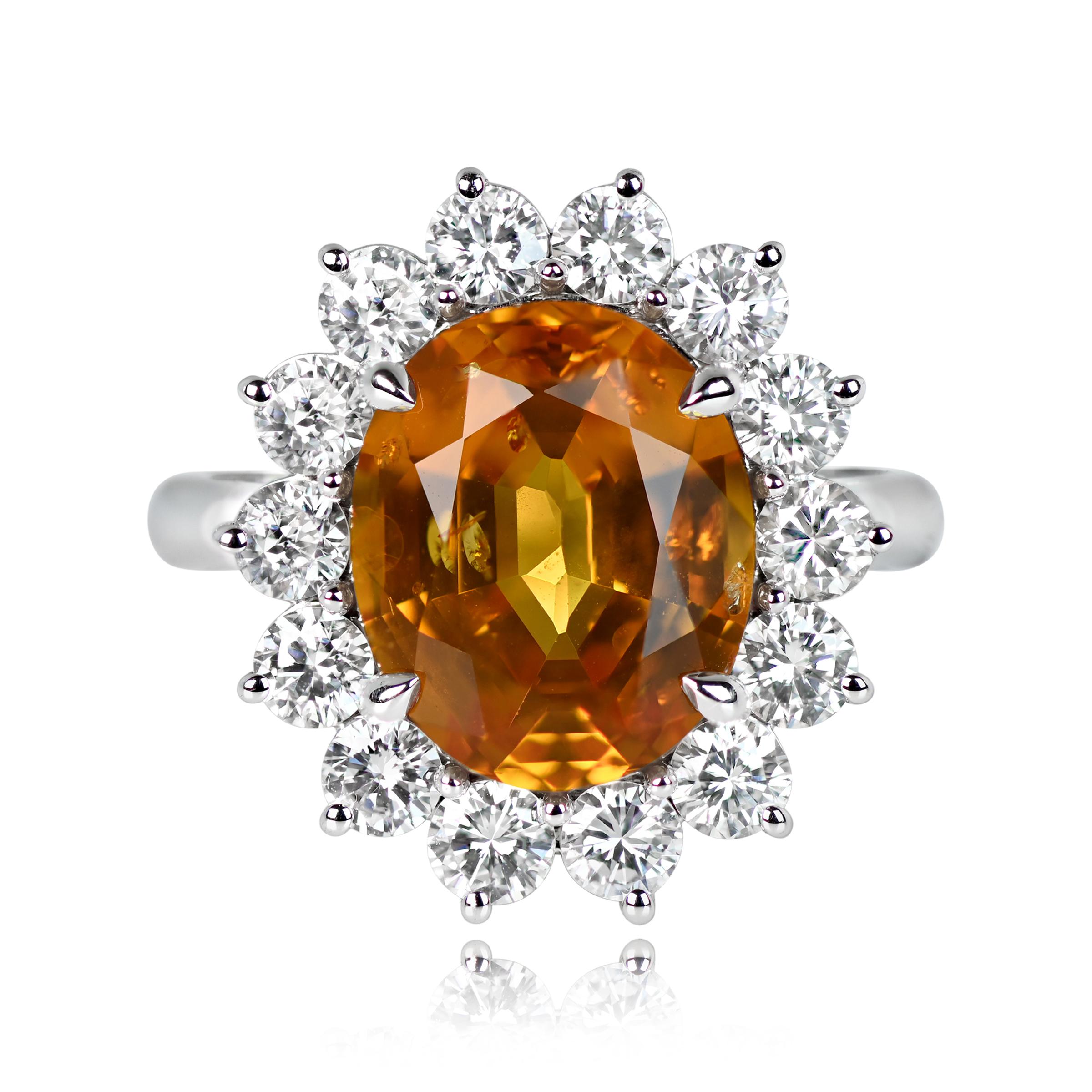 A 5.46 carat oval-cut yellow sapphire takes center stage in this ring, held securely in prongs. Surrounding the sapphire is a dazzling halo of prong-set round brilliant diamonds, totaling 1.36 carats. Handcrafted in 18k white gold, this ring boasts