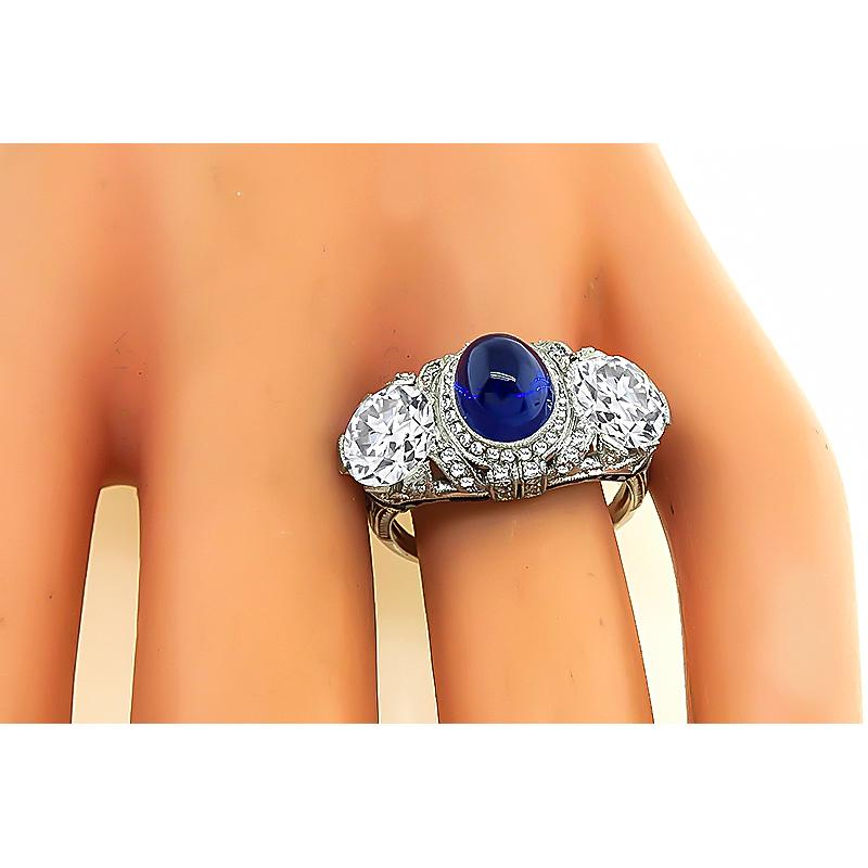 This is a stunning platinum ring from the Art Deco era. The ring is centered with a lovely cabochon AGL and GIA certified no heat Kashmir sapphire that weighs 2.91ct. The sapphire is accentuated by 2 sparkling GIA certified old mine cut diamonds