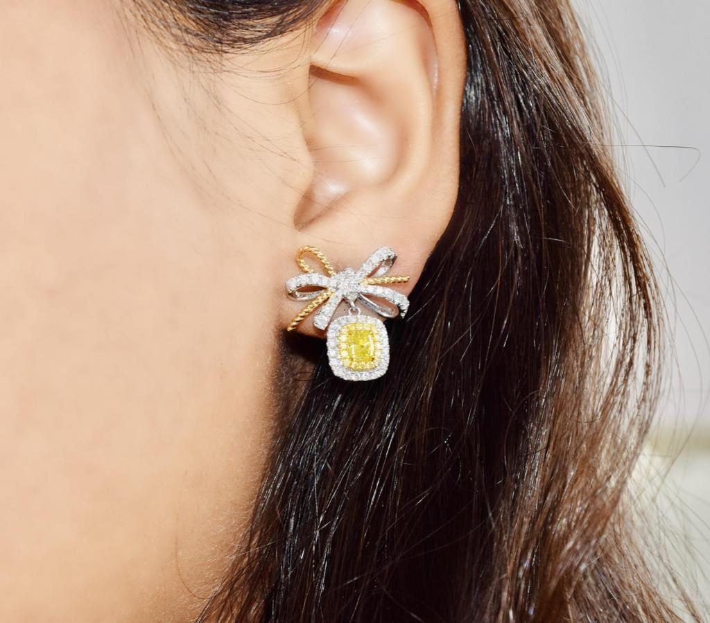 18kt white gold earring with diamonds
  
  Gold colour & karat: White gold 18kt
  Weight: 6.195grams
  
  Set with-
  Stone type: Diamonds
  Shape: Cushion
  Carat: 0.752
  Colour: Fancy Yellow
  Clarity: SI
  
  Surrounding Stones: Diamonds
 1)