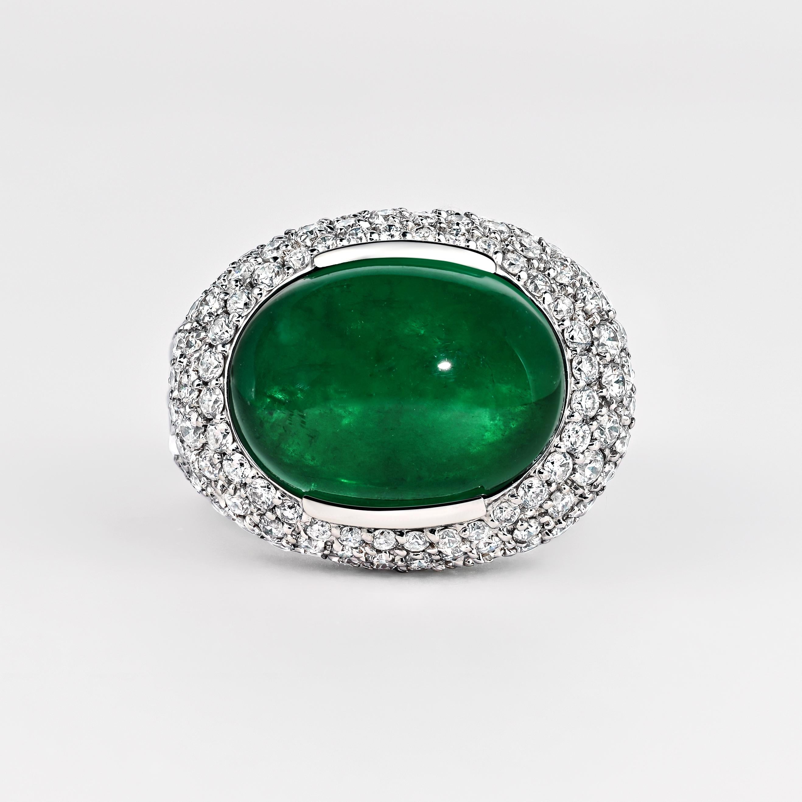 Anello cocktail a grappolo in oro bianco 18 carati. Con uno smeraldo africano minore tagliato a cabochon da 10,12 carati e 4,50 carati di diamanti tagliati a baguette e rotondi. Questo anello sfoggia una splendida estetica simmetrica che fonde gemme