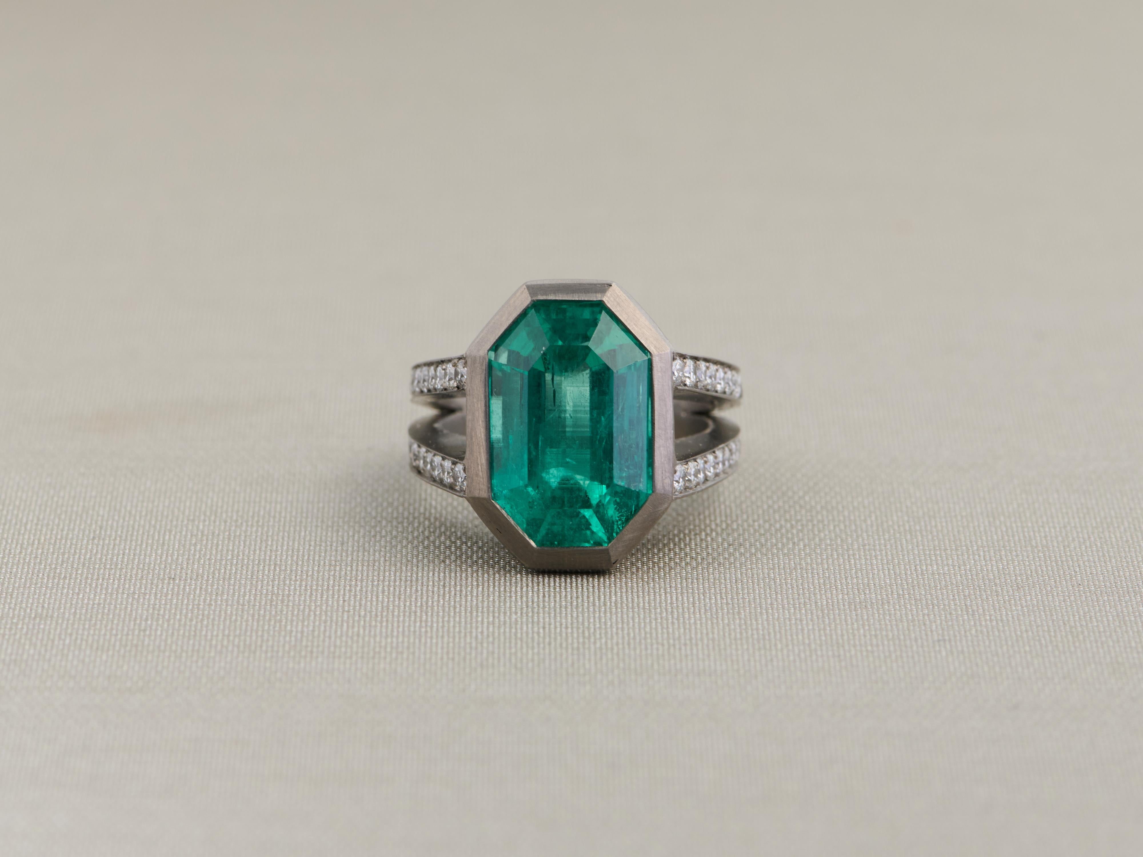 Questo elegante anello presenta uno splendido smeraldo colombiano da 10,25 carati, rinomato per la sua eccezionale qualità e la sua vivida tonalità verde. Lo smeraldo, tagliato a gradini ottagonali e con una piccola lavorazione a olio, mette in