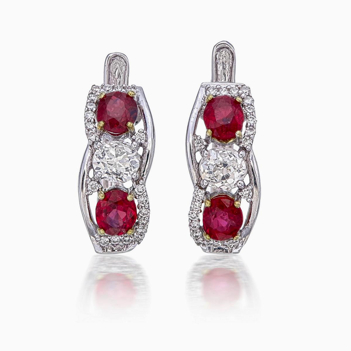 Introducing a beautiful pair of earrings featuring 1.11 carats of rubies, certified as 'Pigeon Blood' by the American Gemological Laboratories (AGL), with certificate number AGL0052991.

These vibrant rubies are surrounded by 0.61 carats of