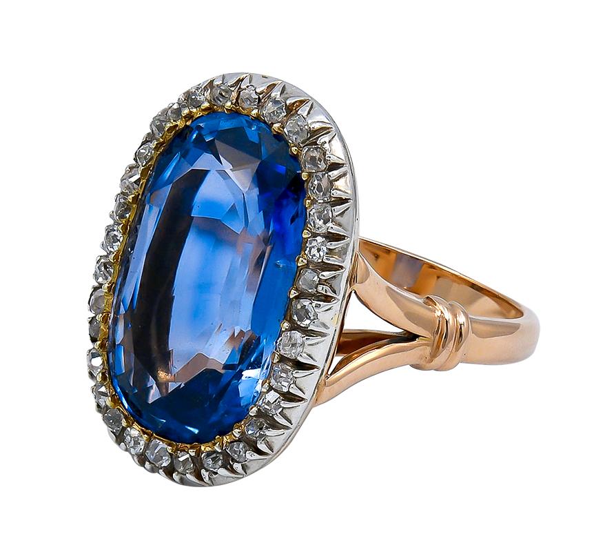 Large, unheated sapphires are rare stones which make great investments and add a pop of color to your jewelry wardrobe. This ring features a lovely cornflower blue center stone enhanced by a halo of sparkling small antique diamonds. The elongated