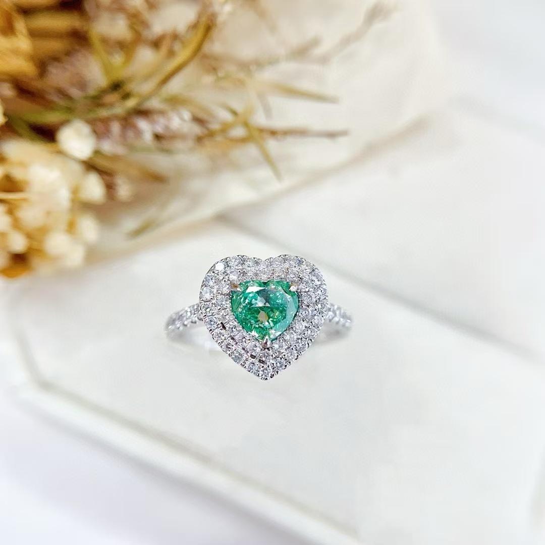 AGL Certified 18K Gold Fancy Green Heart-Cut Diamond Double Halo Ring 

1 Green Diamond - 1.01 CT
Diamonds - 0.53 CT
Total Weight - 3.41 GM

1. Central Green Diamond
The focal point of this ring is a stunning green diamond in a heart shape. Green