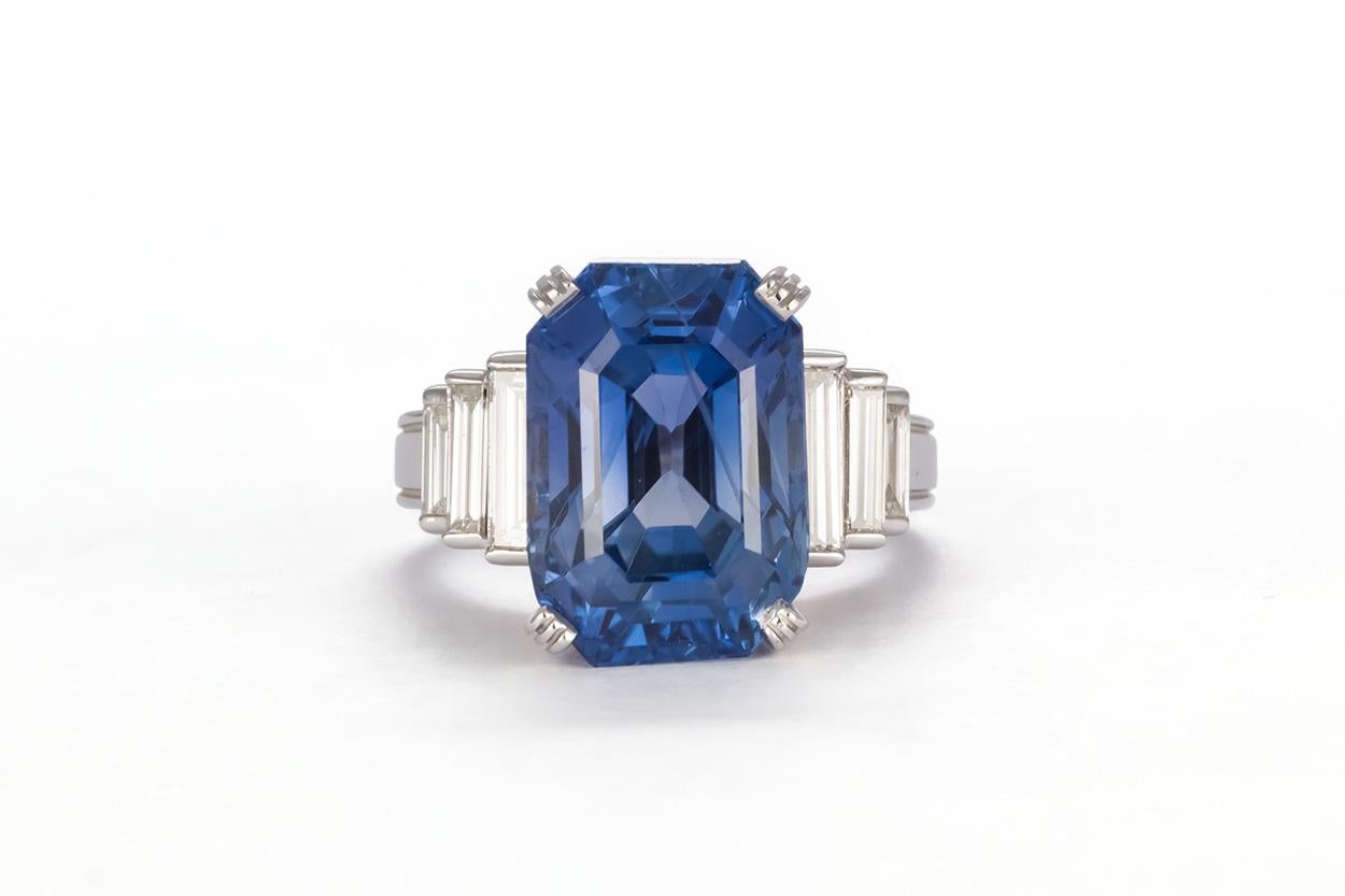 We are pleased to offer this AGL Certified 18k White Gold Ceylon Sapphire & Diamond Ring 14.08ct. This stunning ring feature an AGL Certified 14.08ct emerald cut natural Ceylon sapphire accented by 0.80ctw H/SI1 baguette cut diamonds all set in a