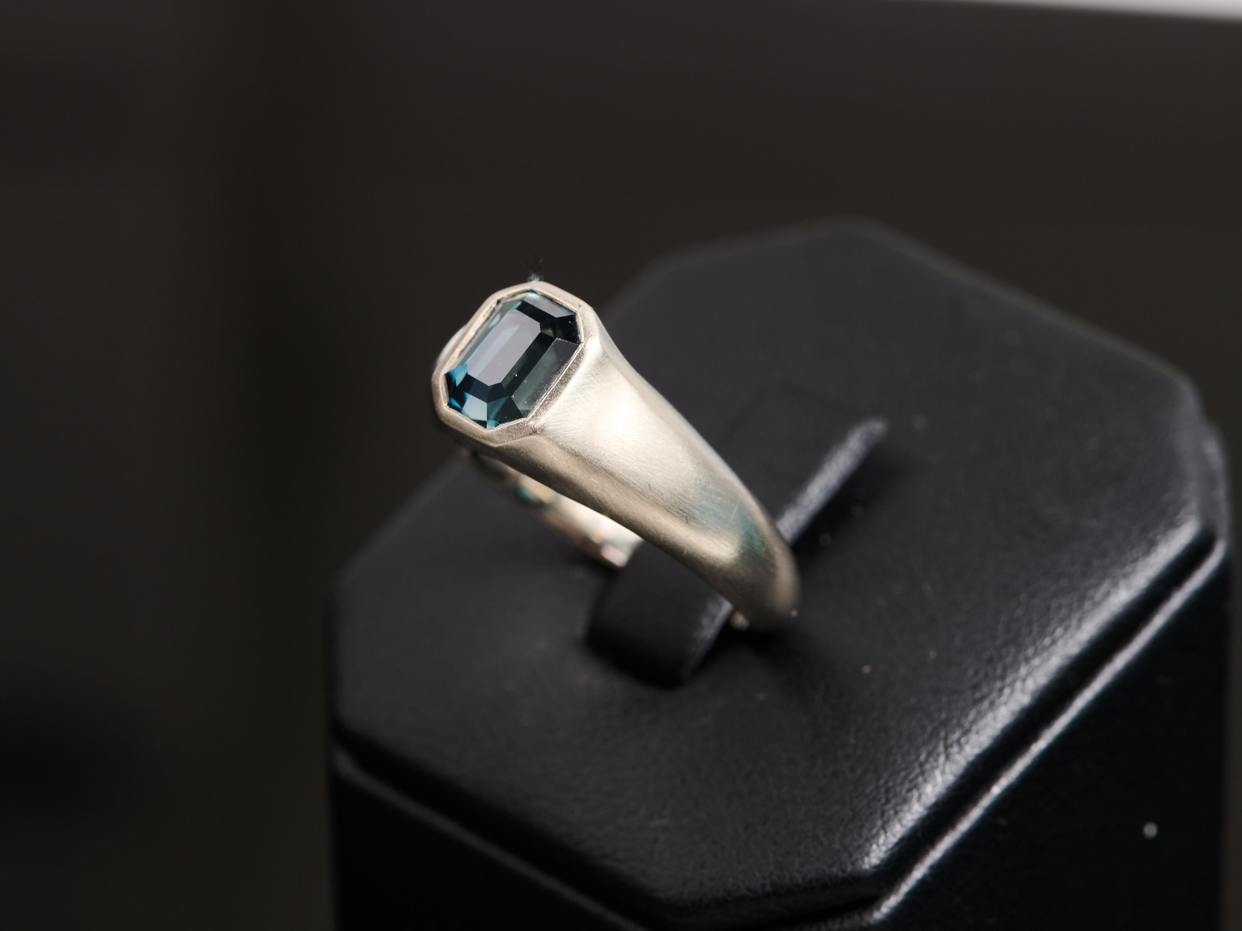 Stunning 2.06ct unheated emerald cut grayish blue sapphire, mounted in a contemporary and minimalistic ring setting. The stone has an AGL certification showing as no treatment. Unheated sapphires are celebrated for their purity and authentic color,